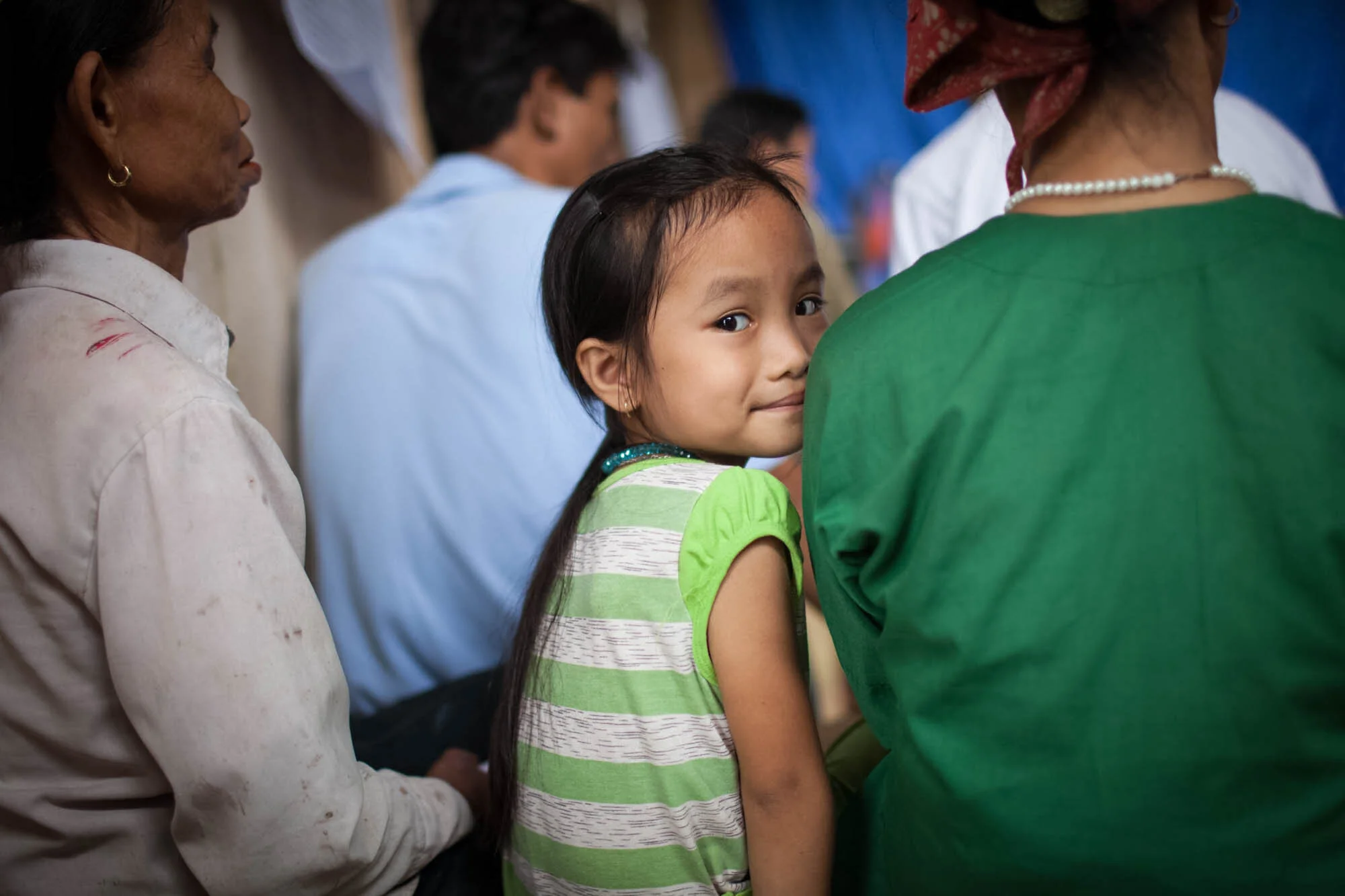  Curious young girl looks at camera during meeting of farmers. 