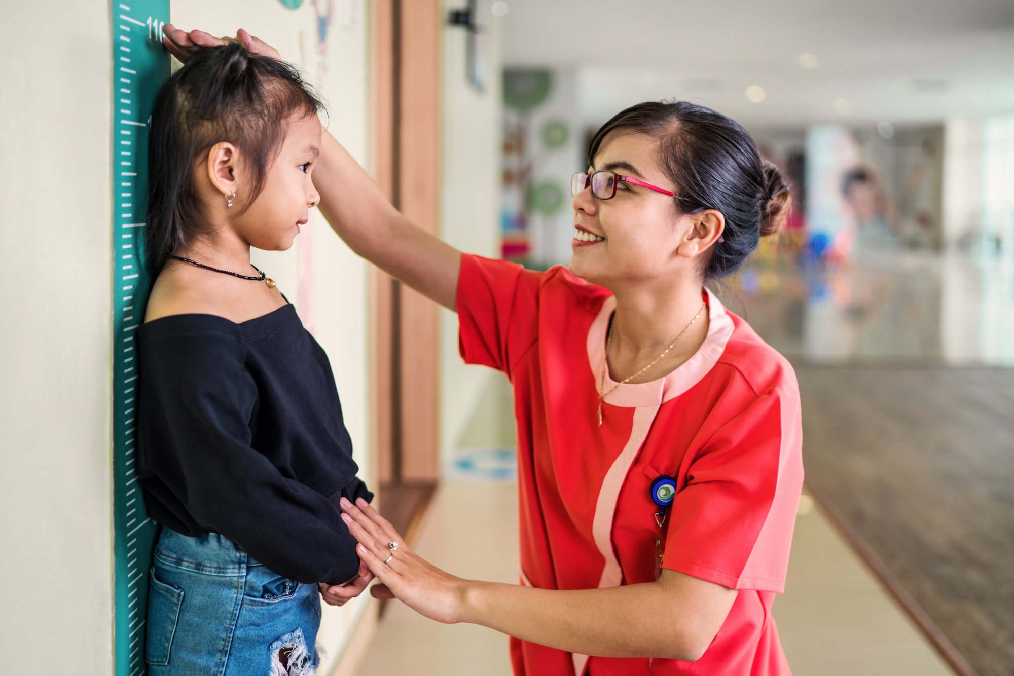 Nurse checks height of young female patient at Hanh Phuc International Hospital.