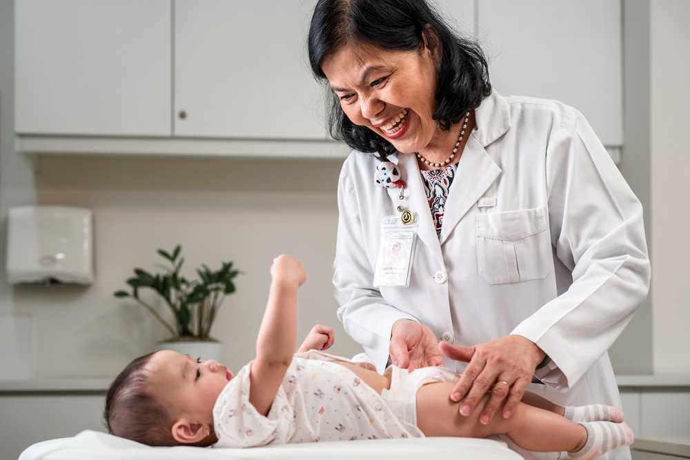 Pediatric Doctor checks health of young baby.