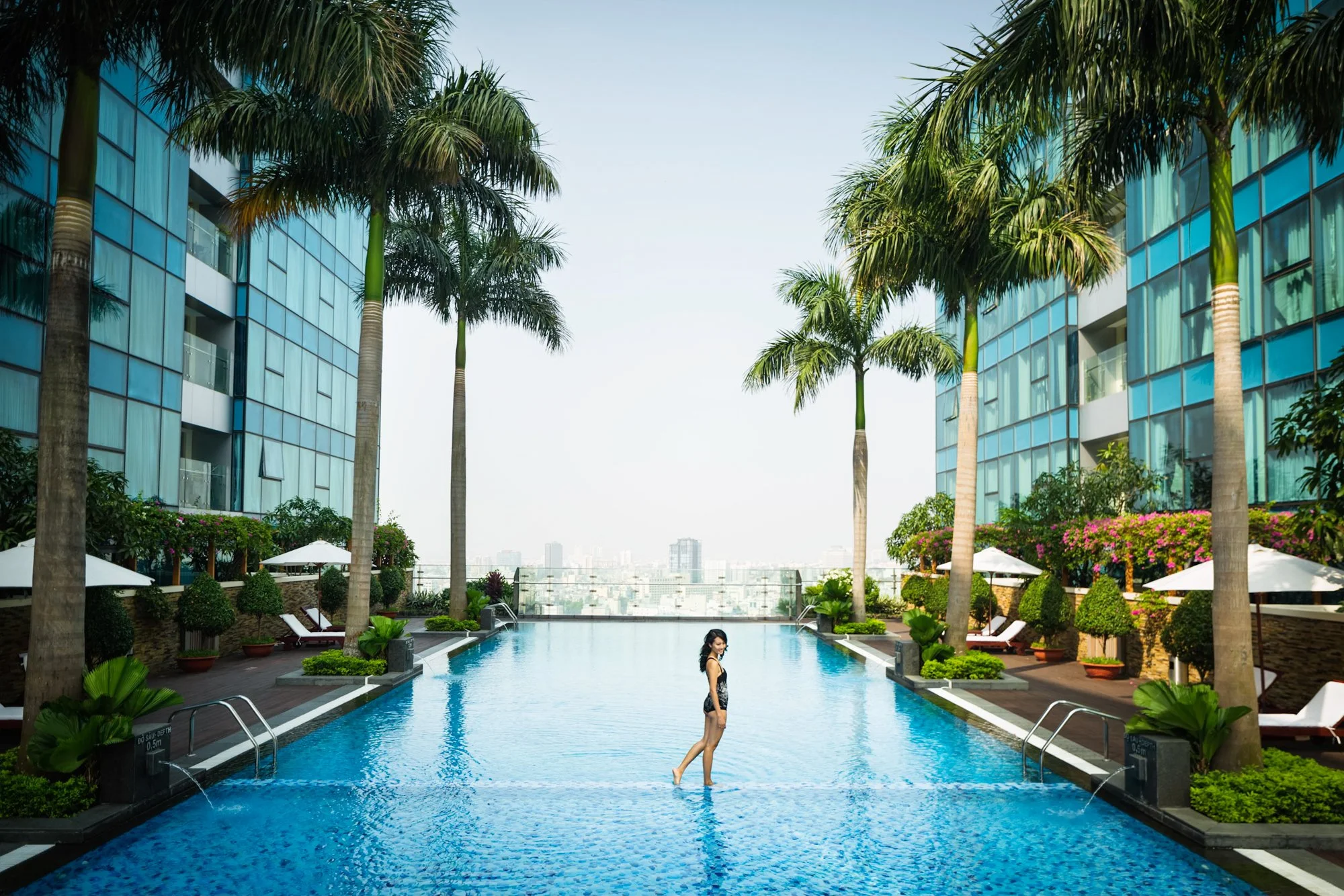  Female walking across the sky pool at Vinhomes Dong Khoi luxury apartments in Ho Chi Minh City. 