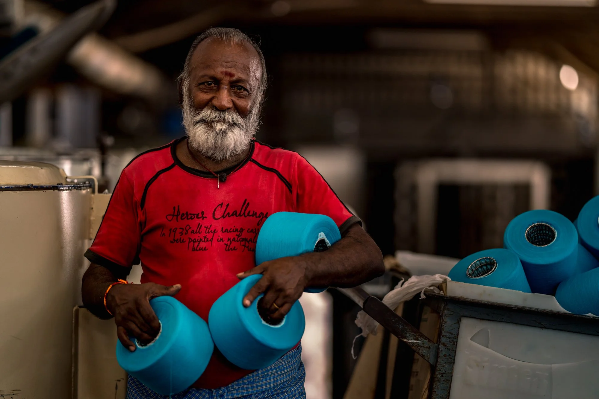  Portrait of Indian worker holding dyed thread at textile factory in Tiruppur, India. 