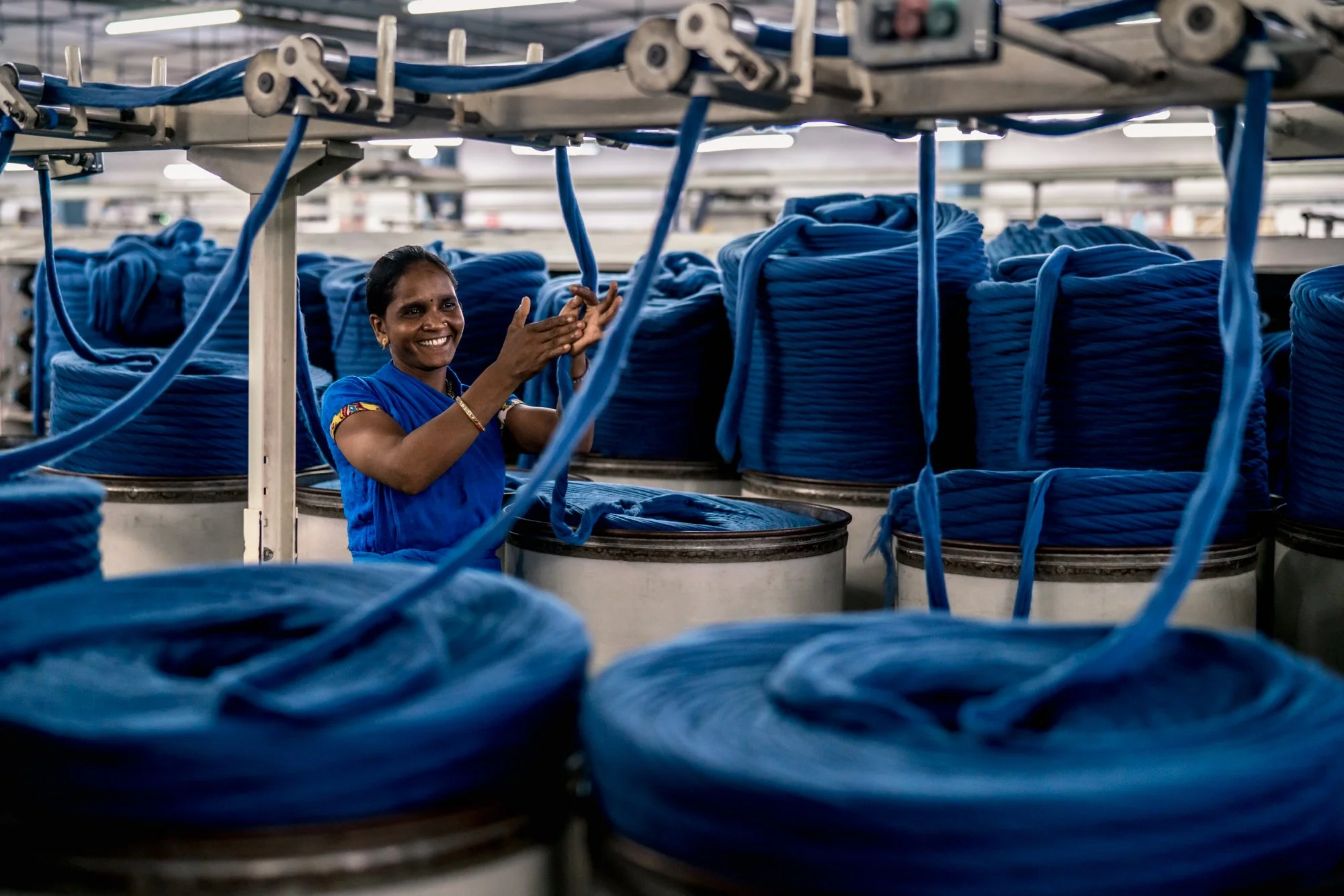  Portrait of Indian woman working on a cotton yarn production line in Banswara Syntex textile factory. 