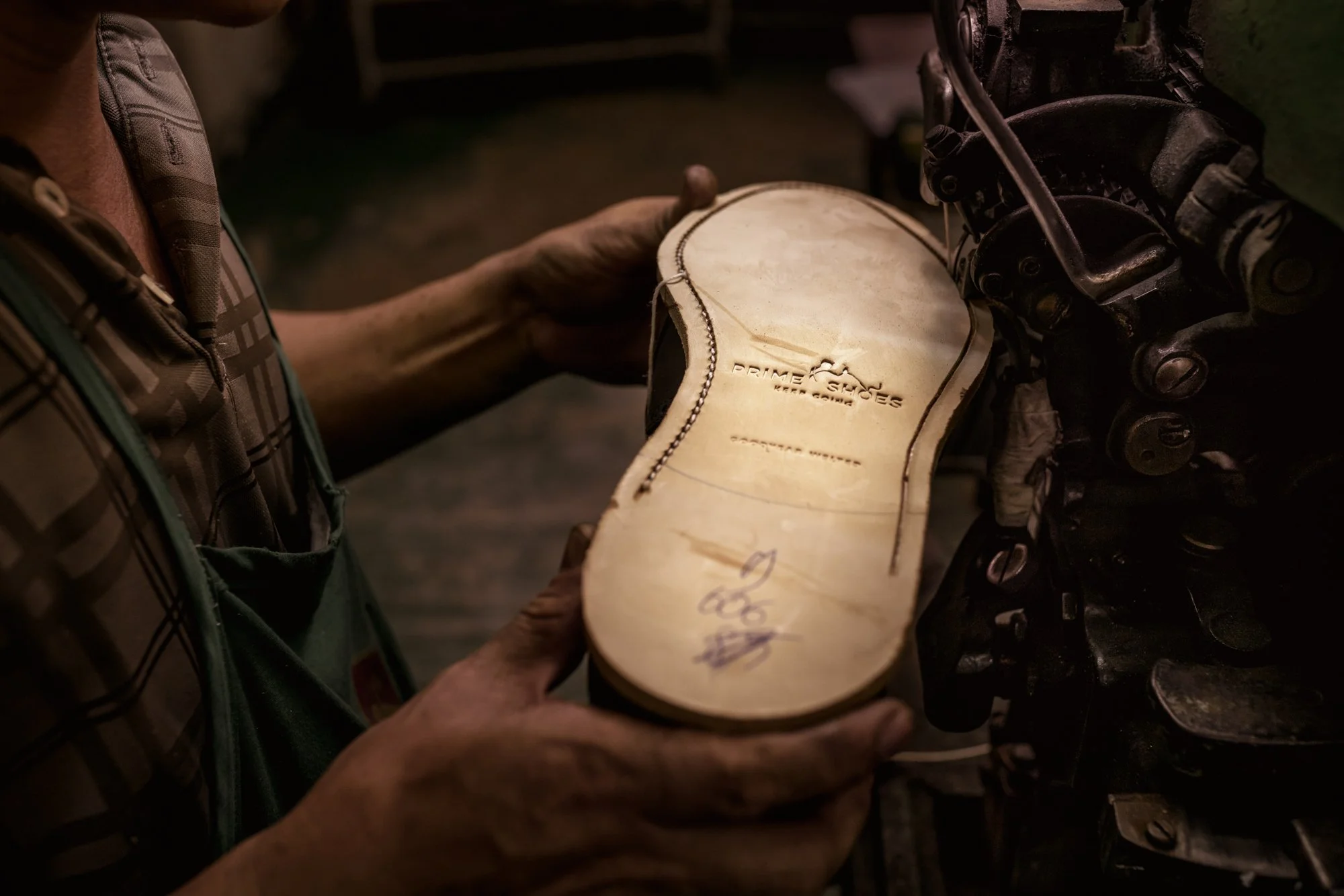  Leather outsole is sewn to the leather frame with the double machine at industrial shoe manufacturing factory. 
