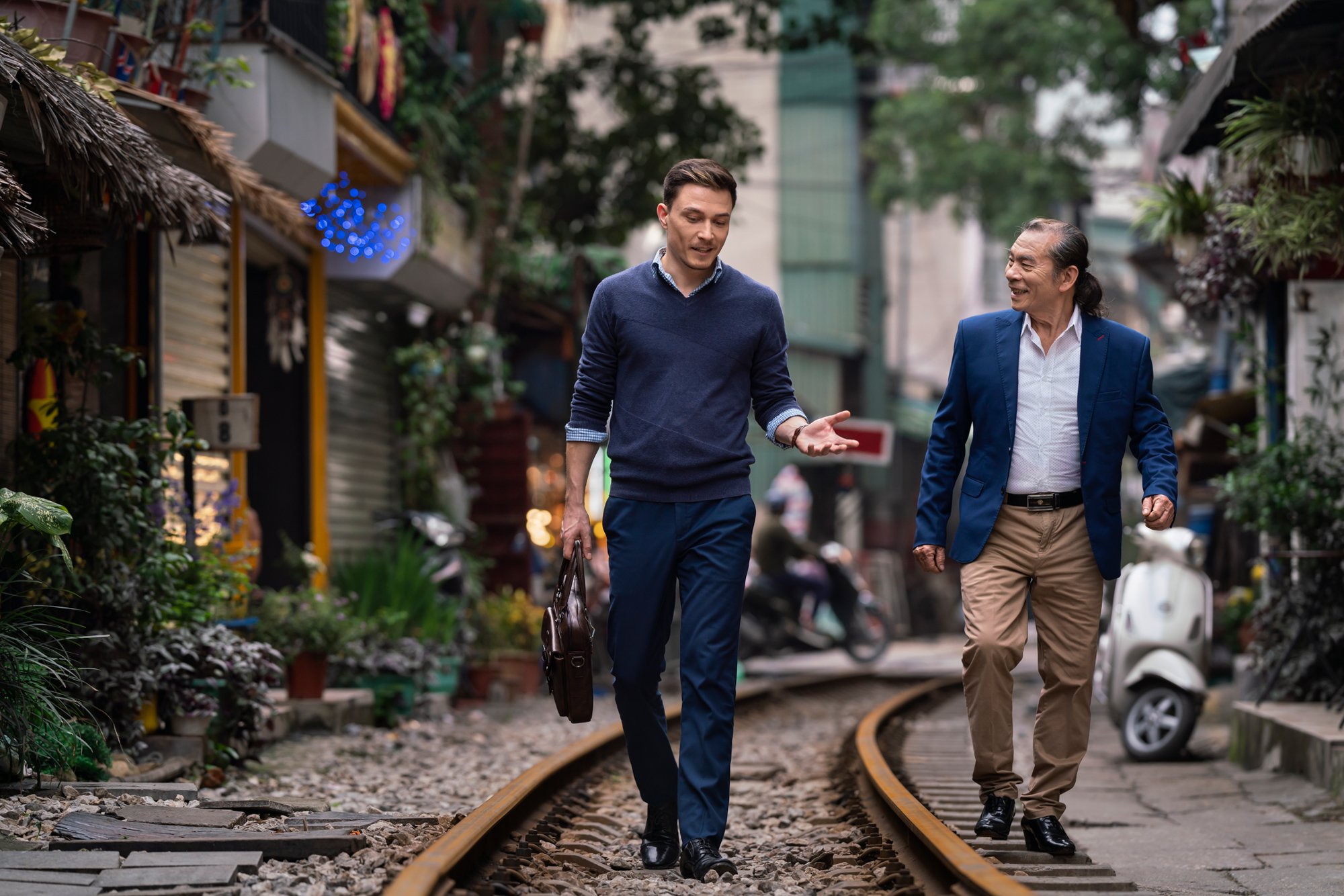  Western entrepreneur and Vietnamese businessman talk business as they walk along train tracks in Hanoi. 