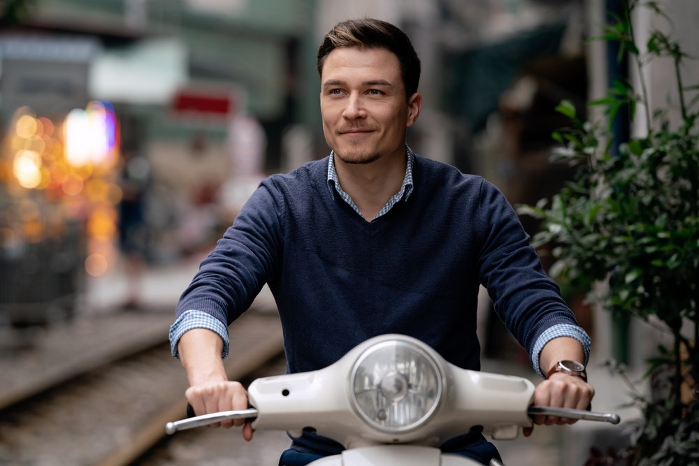  Portrait of western entrepreneur sitting on white motorbike. 