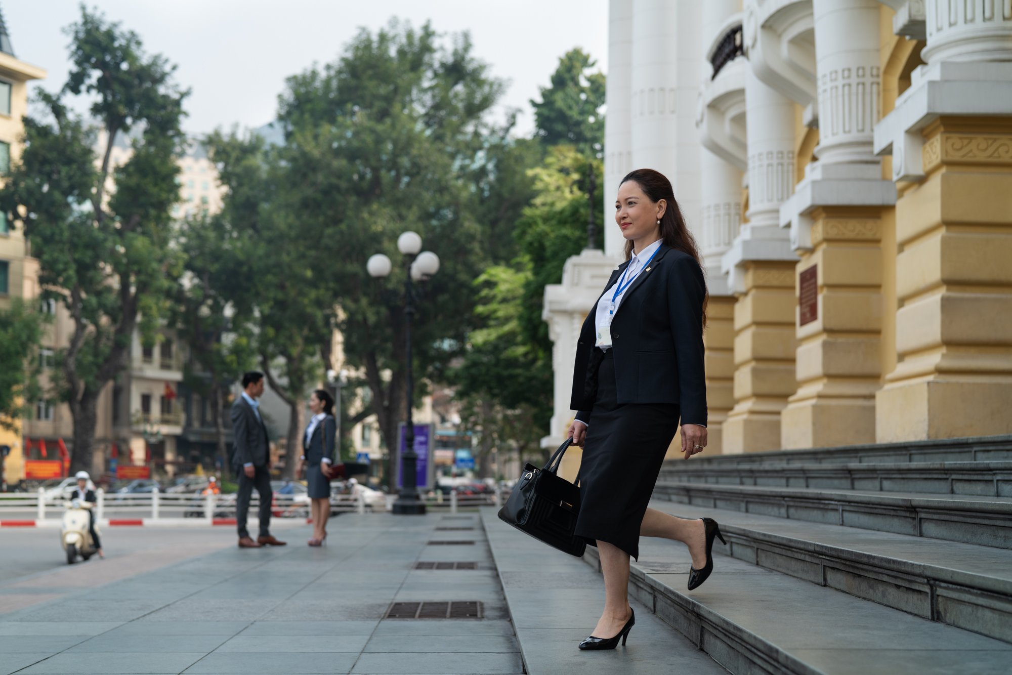  Female regulatory officer walks briskly down steps as she leaves work. 