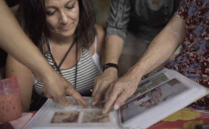Frame grab as Juliet looks through old photo album with her relatives during the Together documentary.