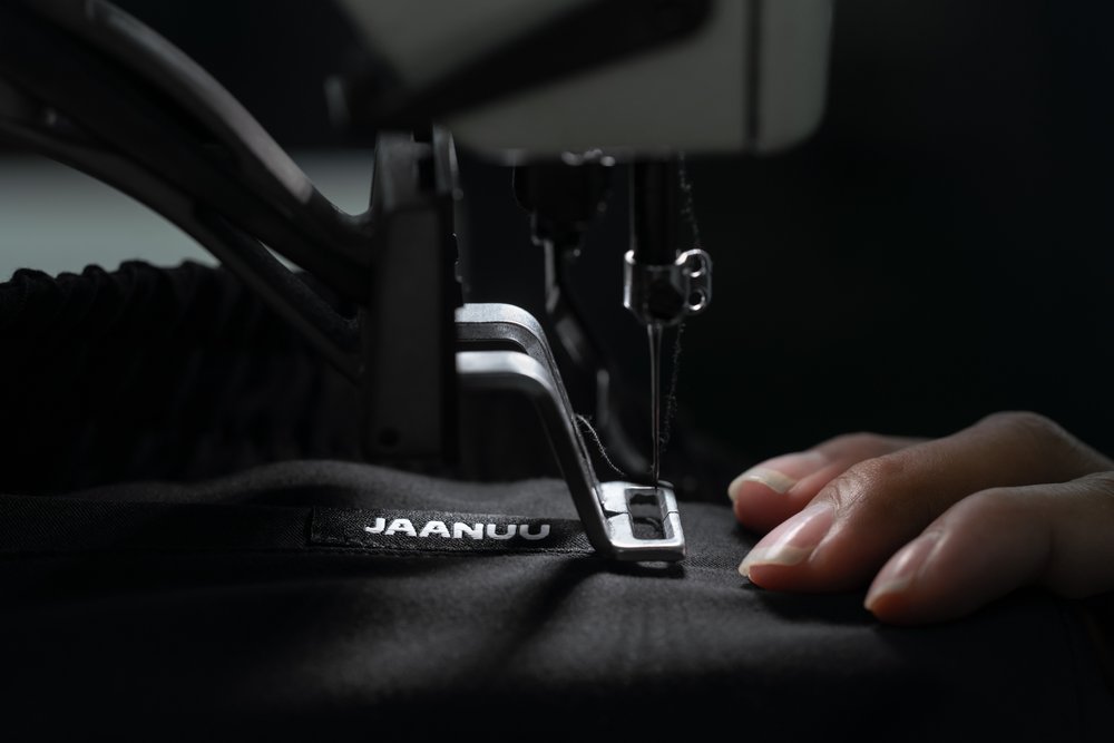 Detail as Jaanuu label is sewed onto textile design.