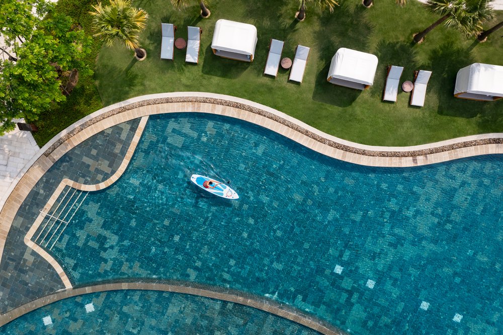  Lifestyle image of paddle boarder in the Cove pool at New World Hoiana Beach Resort. 
