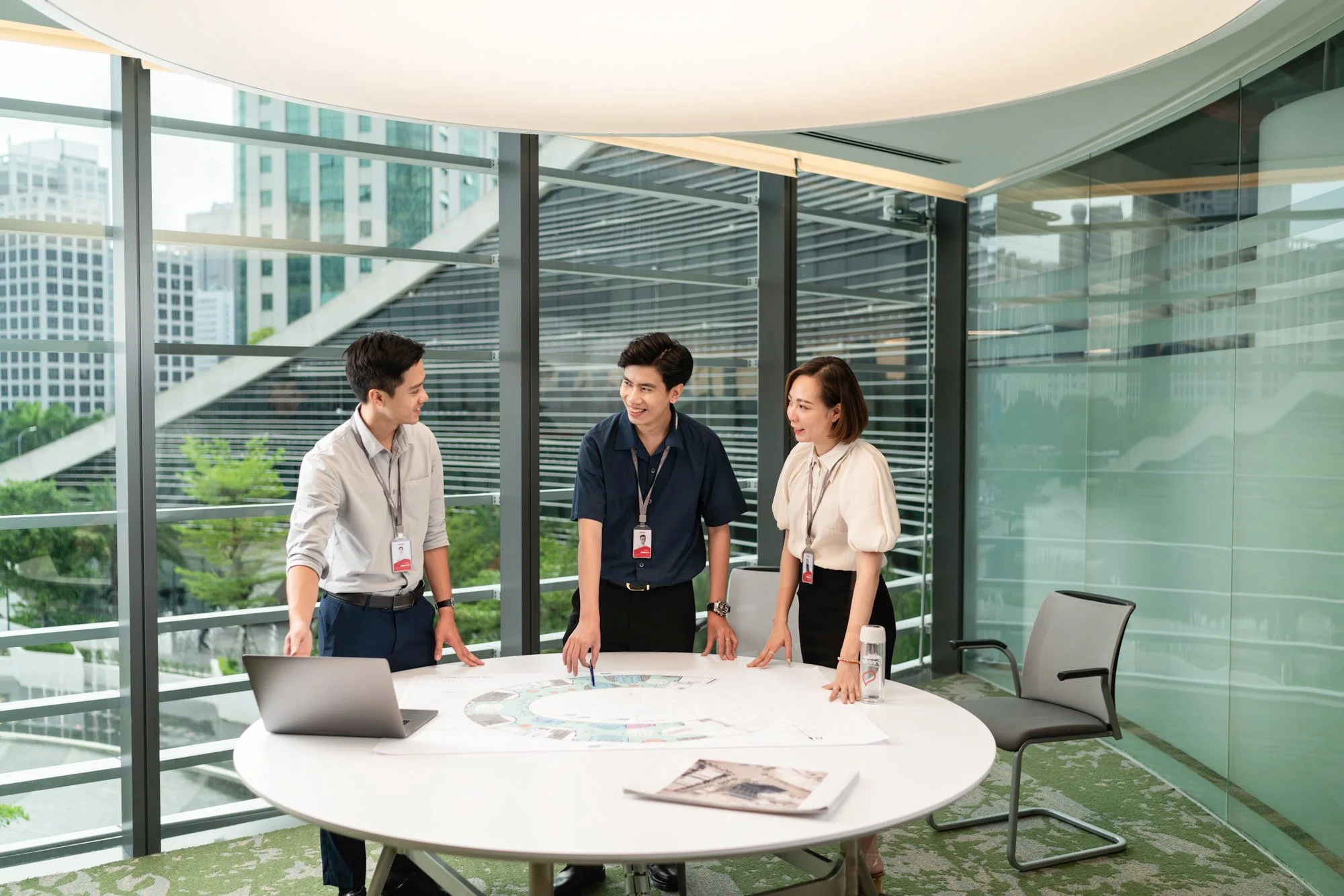  Viettel Group consultant team meet to discuss design plans in meeting room at their corporate headquarters. 