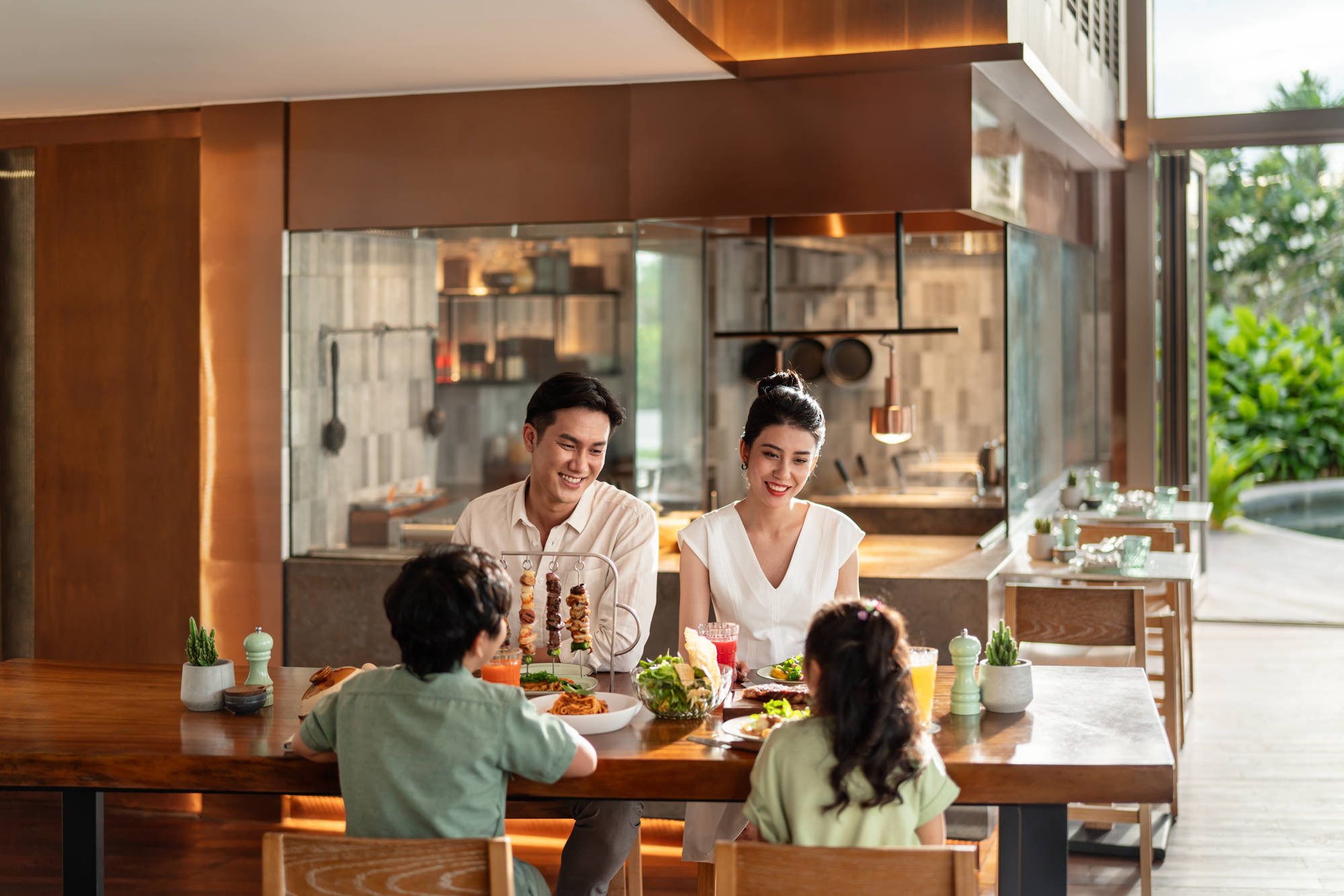  Family enjoying a meal indoors at Charred Restaurant, New World Hoiana Beach Resort. 