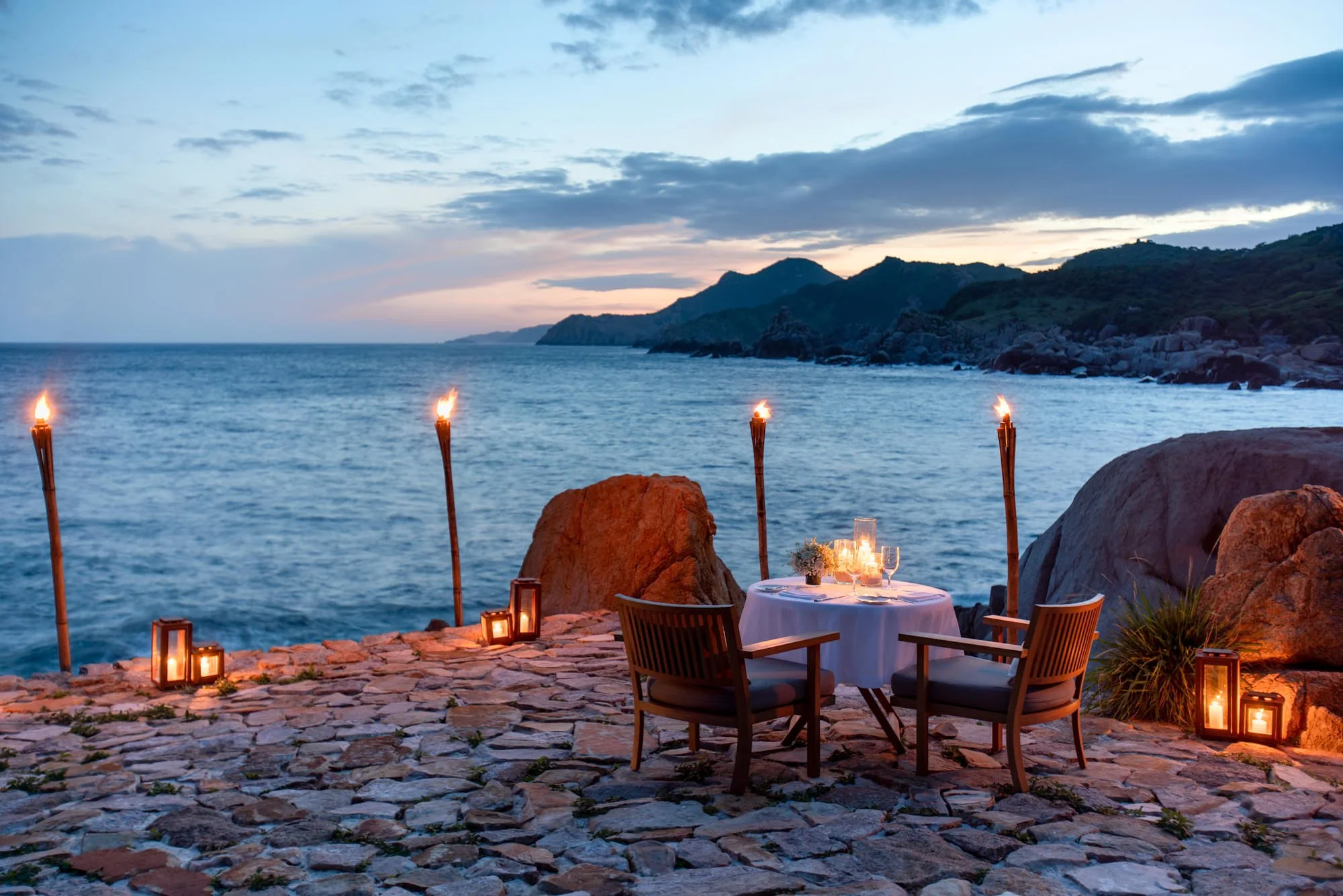  Romantic candelit table setting for two at seaside private dining deck with view to ocean in Amanoi Residence. 
