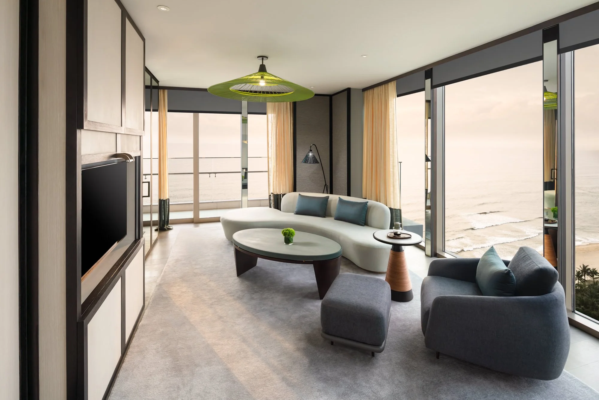  Premier Ocean Suite living room at New World Hoiana Beach Resort, featuring contemporary furnishings, a spacious seating area and floor-to-ceiling windows overlooking the ocean. 
