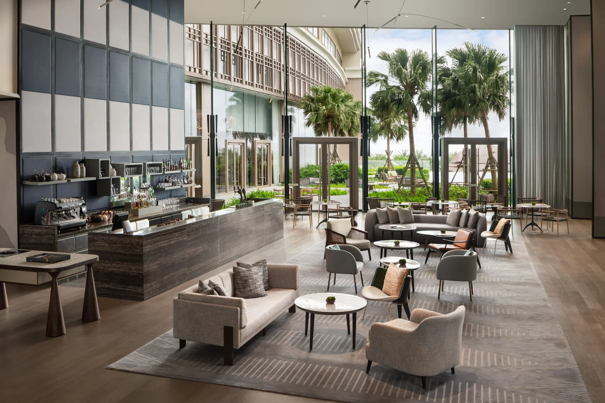  The Commons Lounge and Bar at New World Hoiana Beach Resort, with a relaxed contemporary interior and views towards the resort’s landscaped grounds and ocean. 