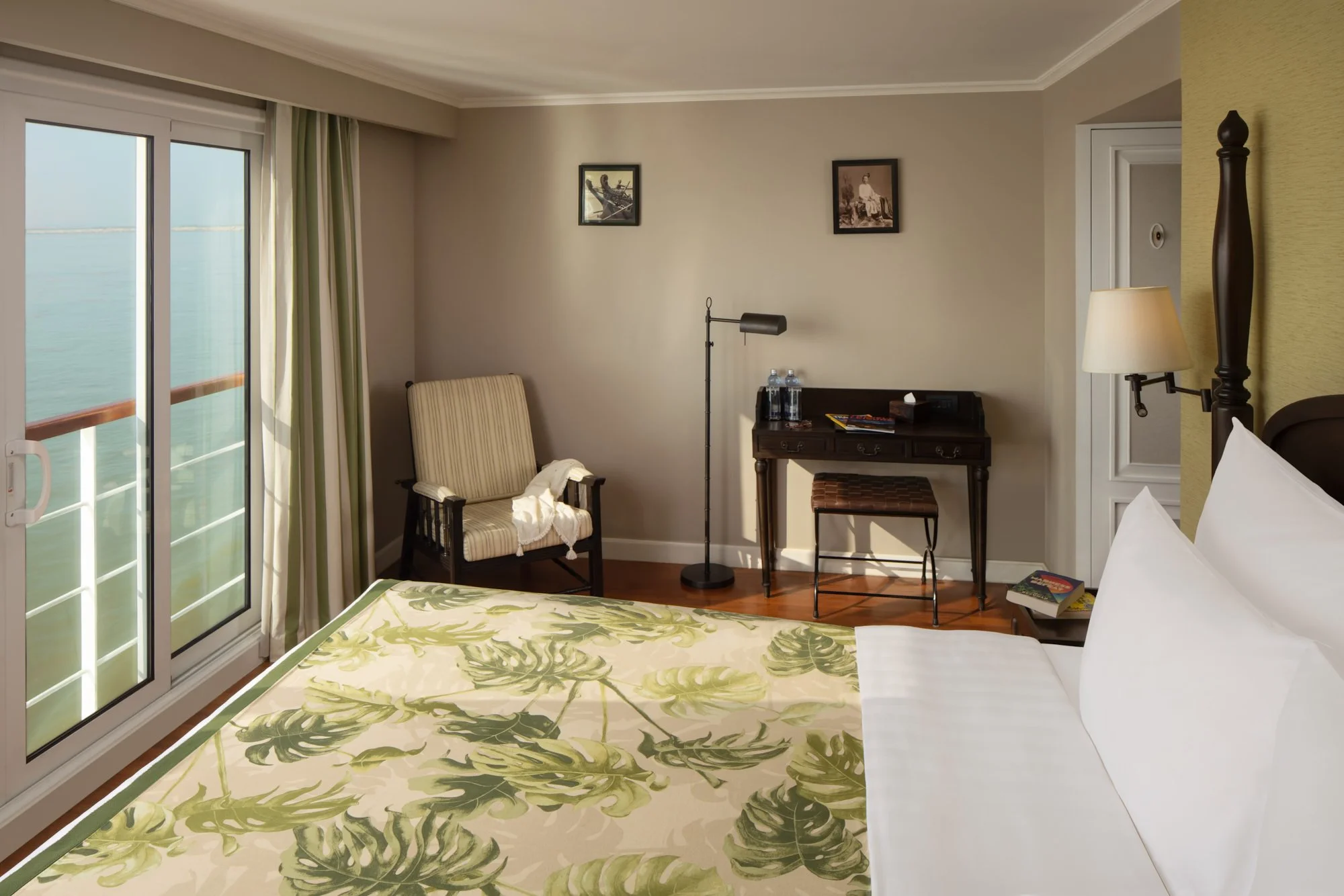  Double-bed guest cabin aboard The Strand Cruise on the Irrawaddy River in Myanmar, with elegant furnishings and sliding glass doors opening to views of the river. 