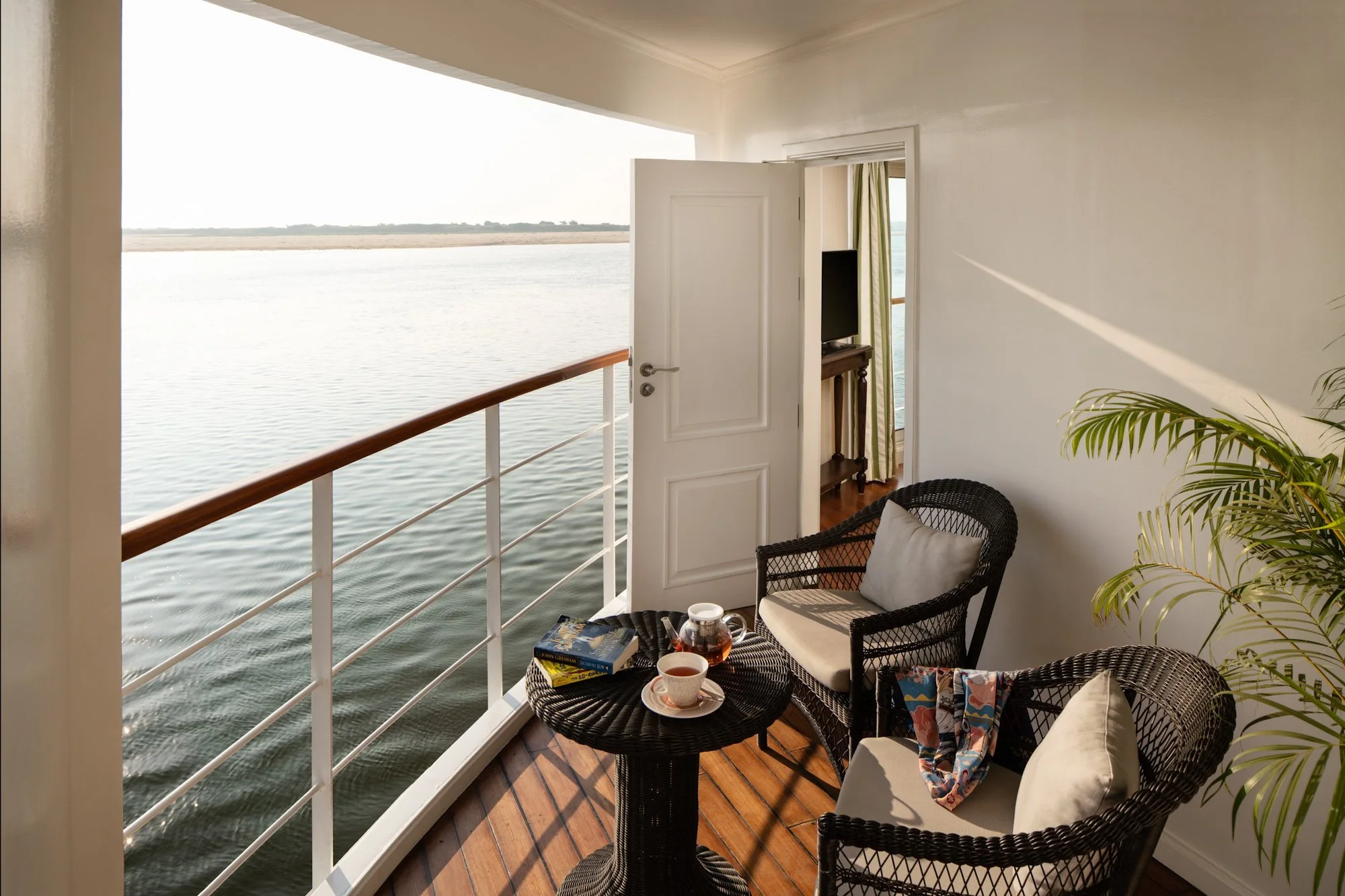  Private balcony of a Strand Suite aboard The Strand Cruise in Myanmar, offering guests a peaceful space to relax and enjoy views of the Irrawaddy River and surrounding landscapes during the cruise. 