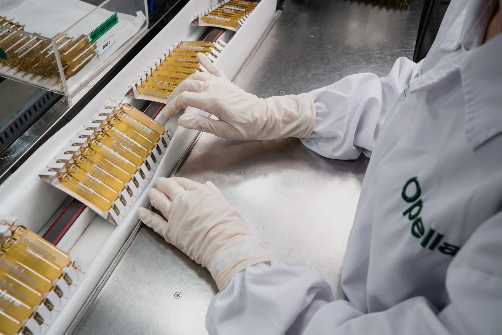  Lab technician in protective gloves and a white coat inspects Corbiere Calcium Plus tubes at the Opella manufacturing facility in Ho Chi Minh City, Vietnam. 