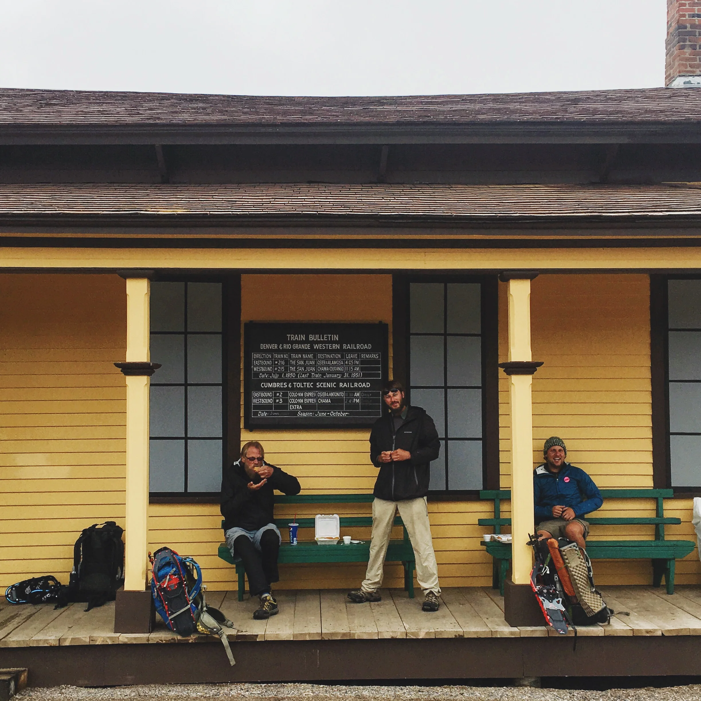Lodgepole, Maverick, and Banjo eat town snacks at the Cumbres Pass train station before braving the elements again.