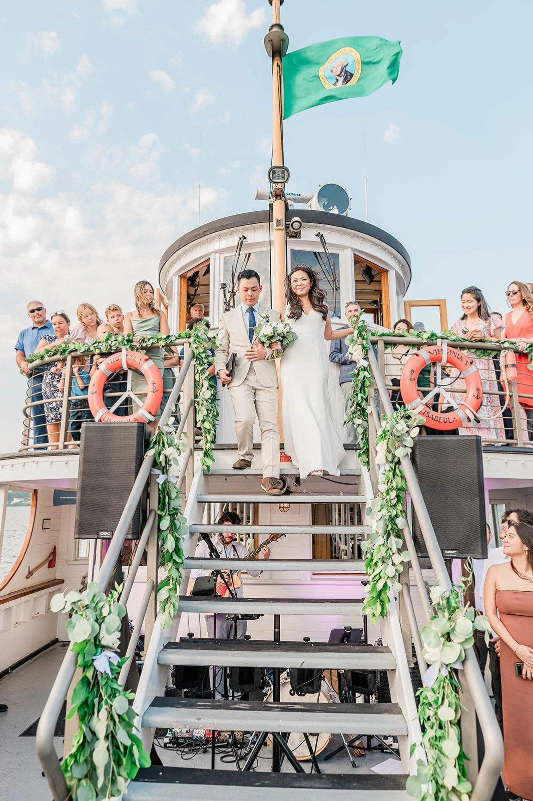 Newlyweds walking down the garland-lined staircase of the Virginia V