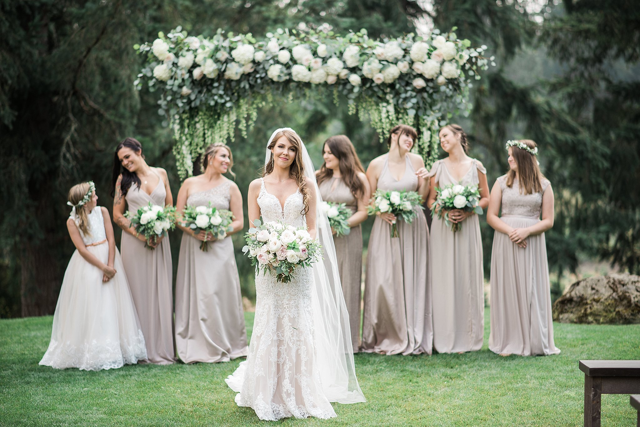 The bride & her bridesmaids in front a gorgeous white & green fl