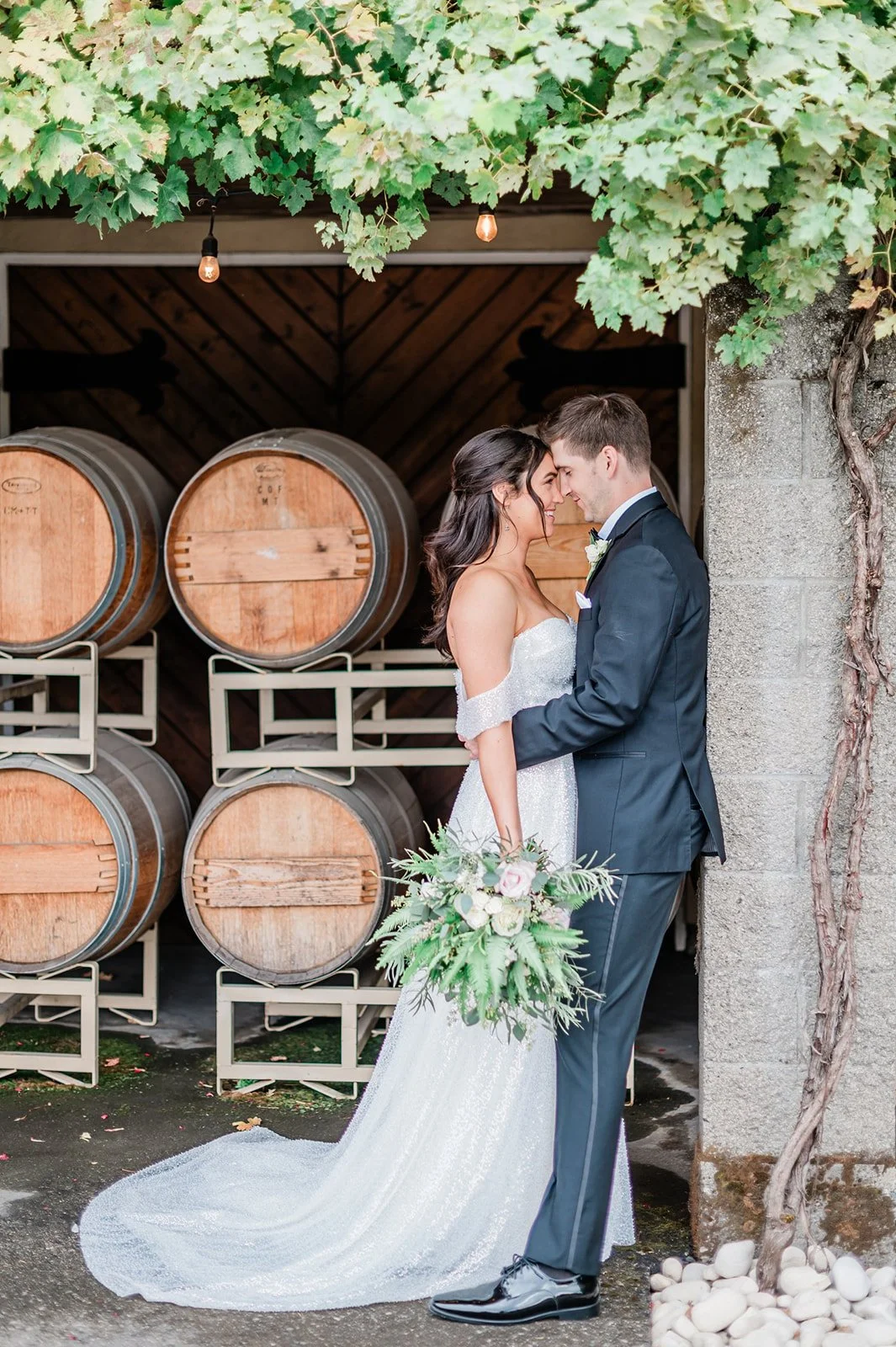 Couple portrait during golden hour at Chateau Lill winery in Woodinville WA with the vineyard and French chateau visible behind them