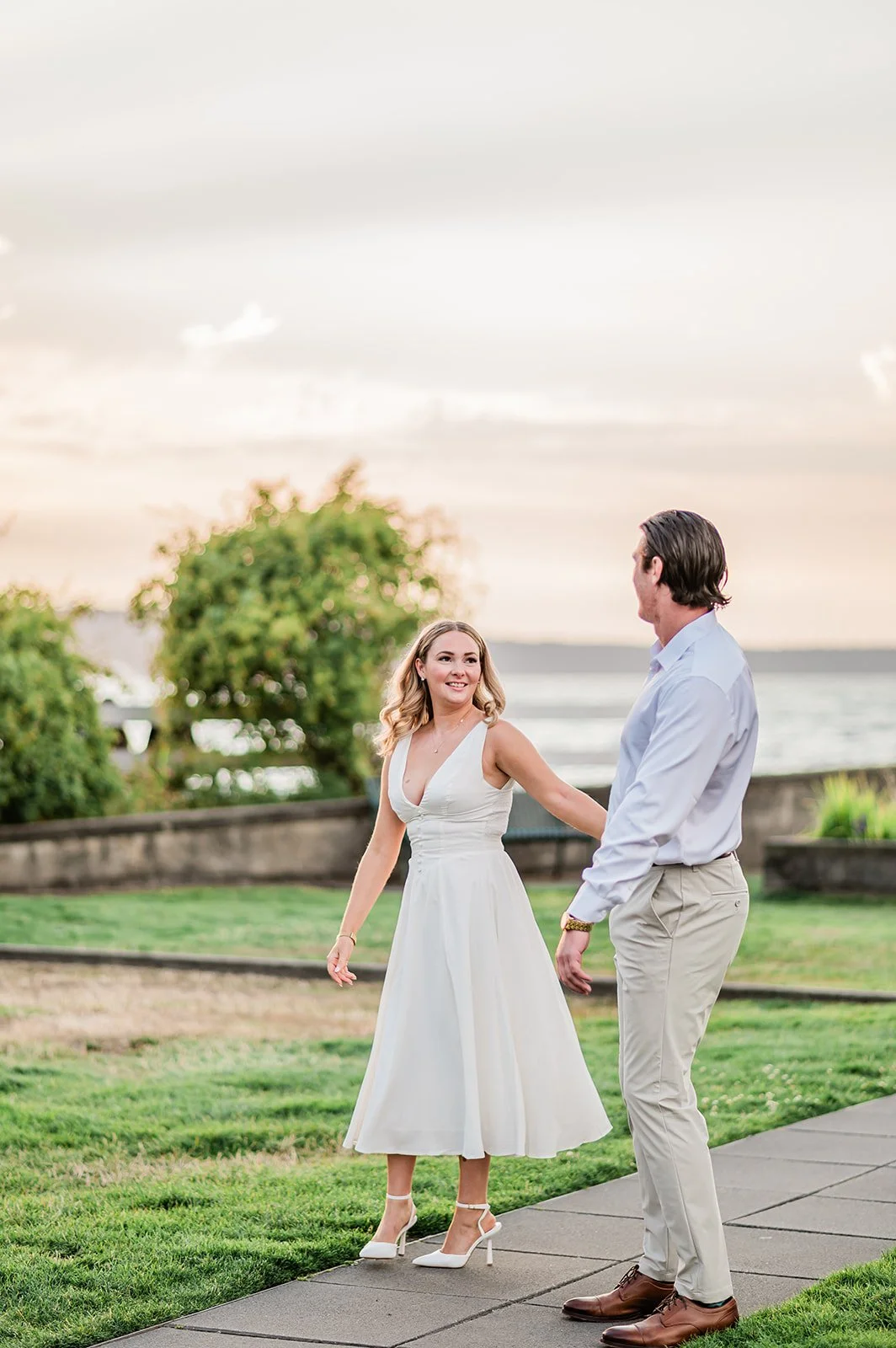 Fiancée twirling in a white midi dress at Mukilteo Lighthouse Park