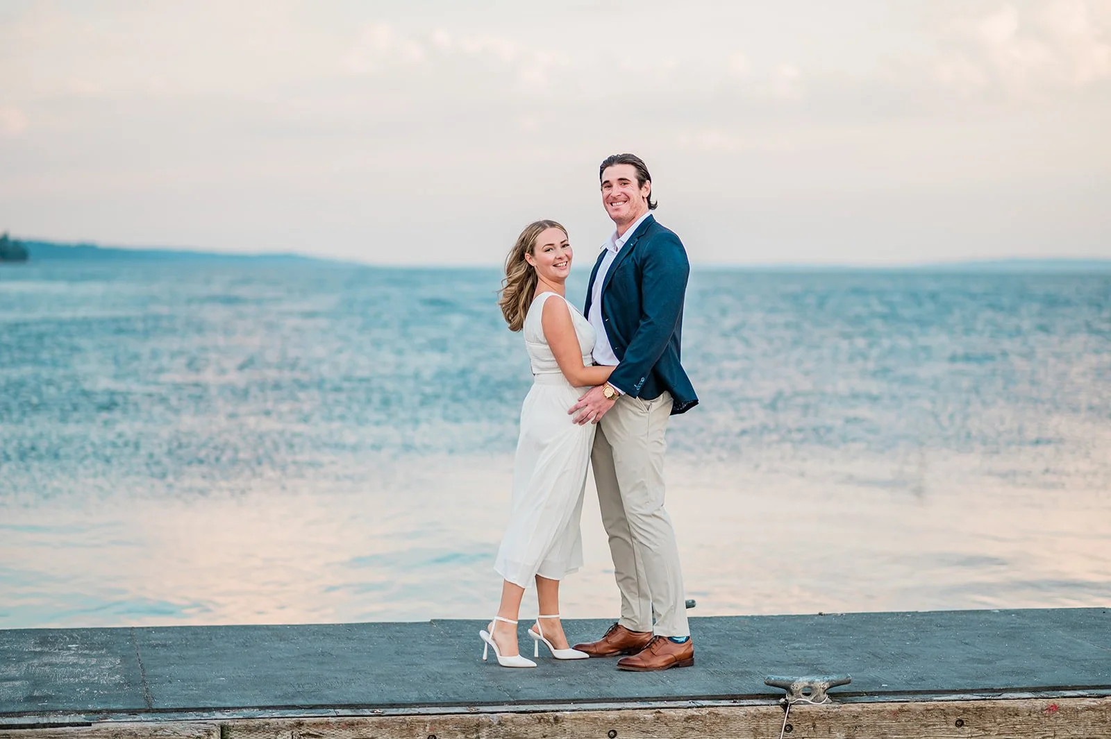 Couple on the boat launch dock with blue water and sky at Mukilteo