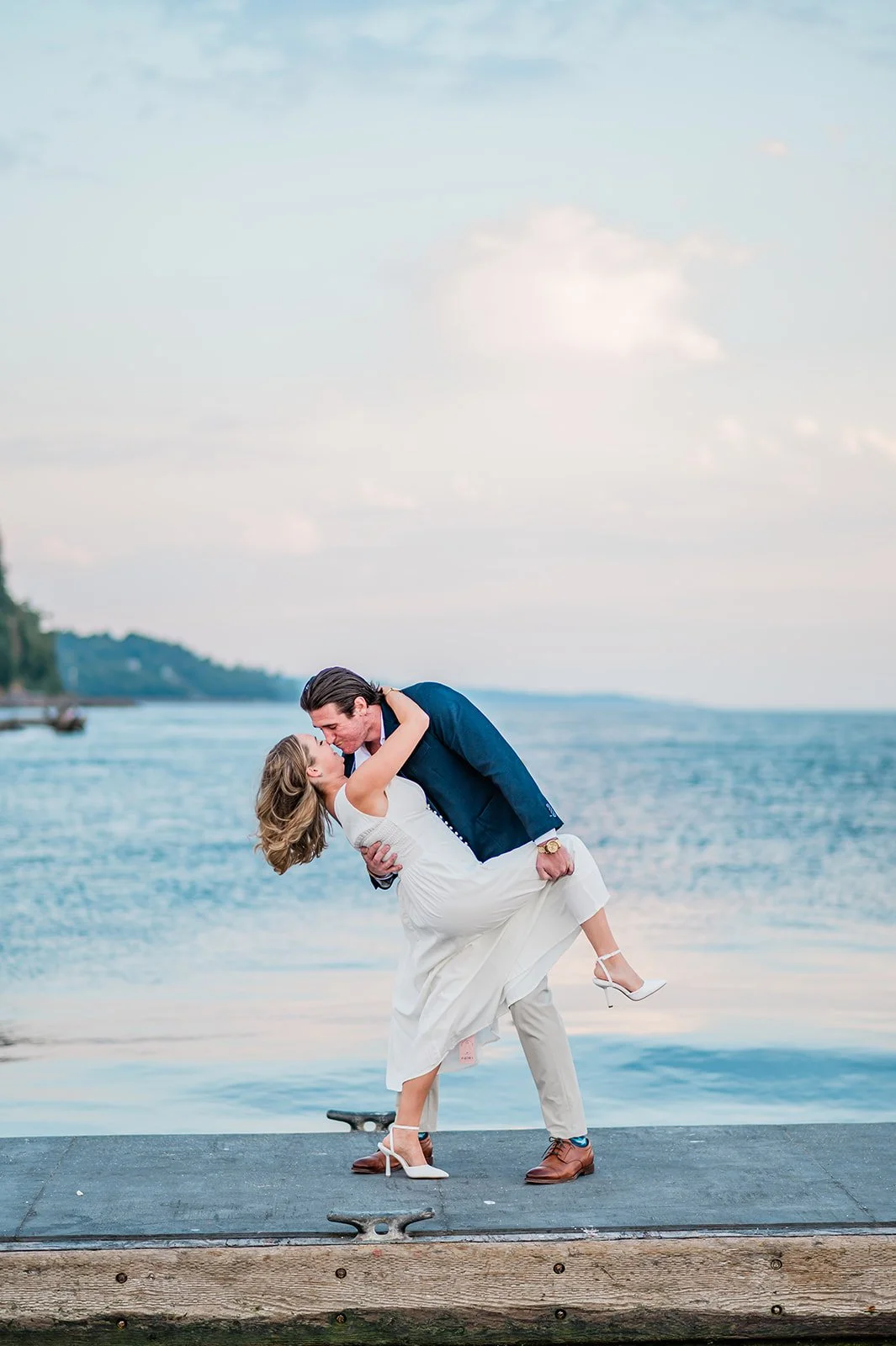 Dip kiss on the dock over bright blue water at Mukilteo Lighthouse Park
