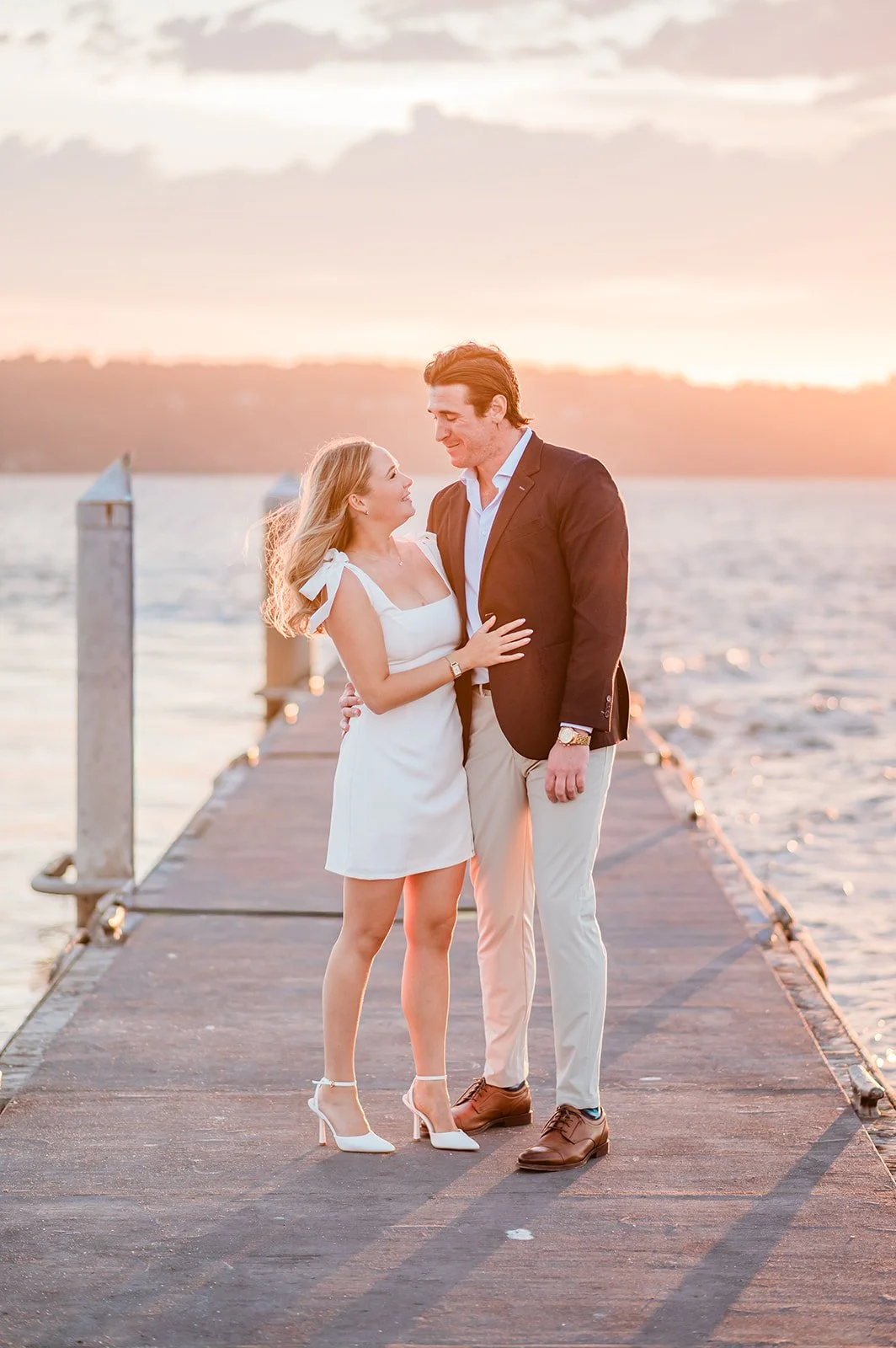 Couple laughing together on the Mukilteo dock at sunset