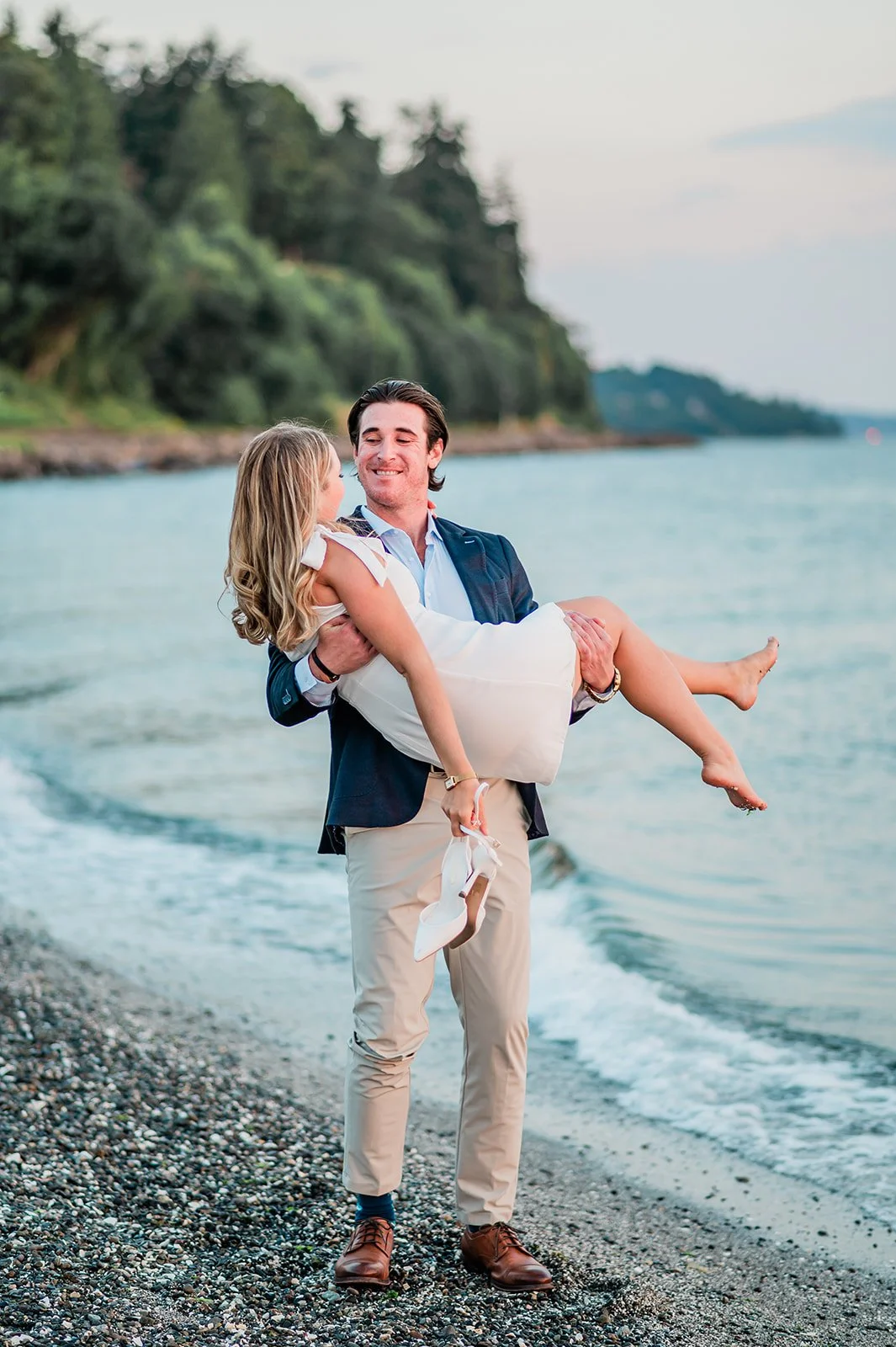 Fiancé carrying fiancée through the waves at Mukilteo beach