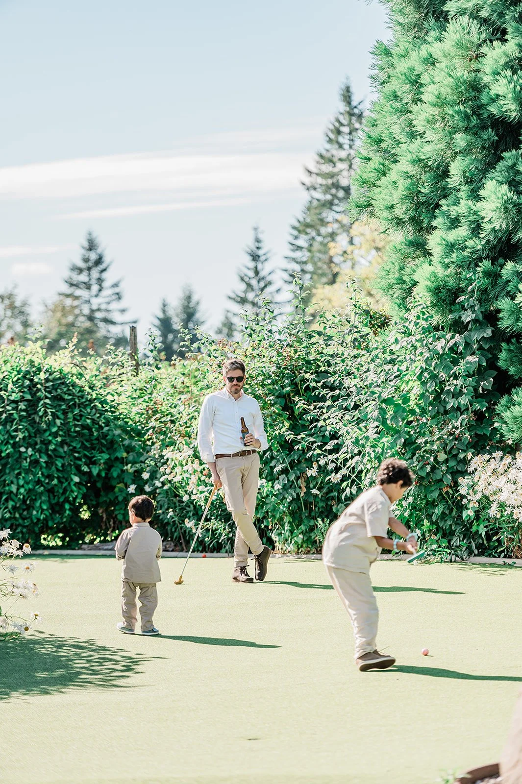 Wedding guest and two young boys playing on the putting green at The Carey Gardens in Snohomish