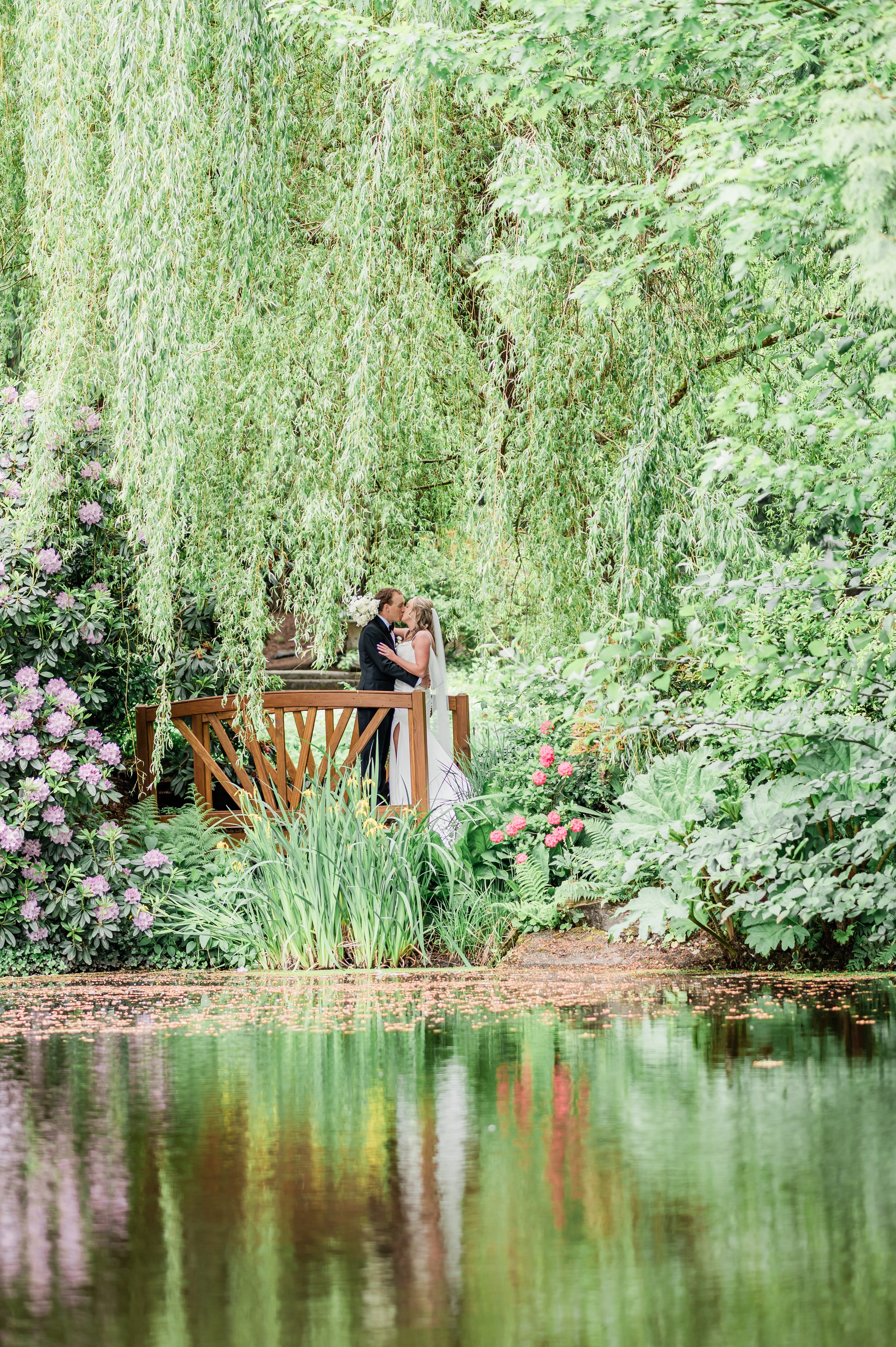 Couple portrait on the bridge at Chateau Lill overlooking the main pond in Woodinville WA at sunset