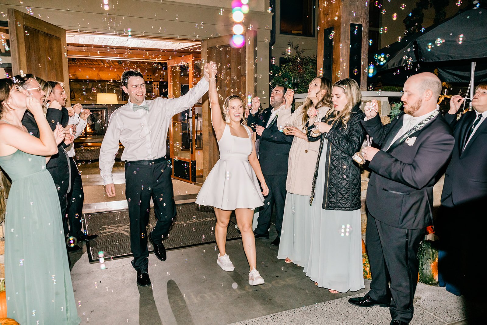 Bride and groom's grand exit under a bubble send-off with their wedding party at Willows Lodge
