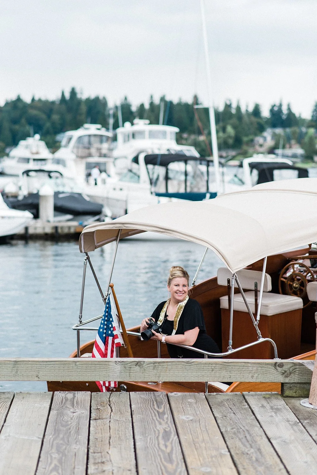 Becca Jones, Seattle boat wedding photographer, holding her camera on a boat