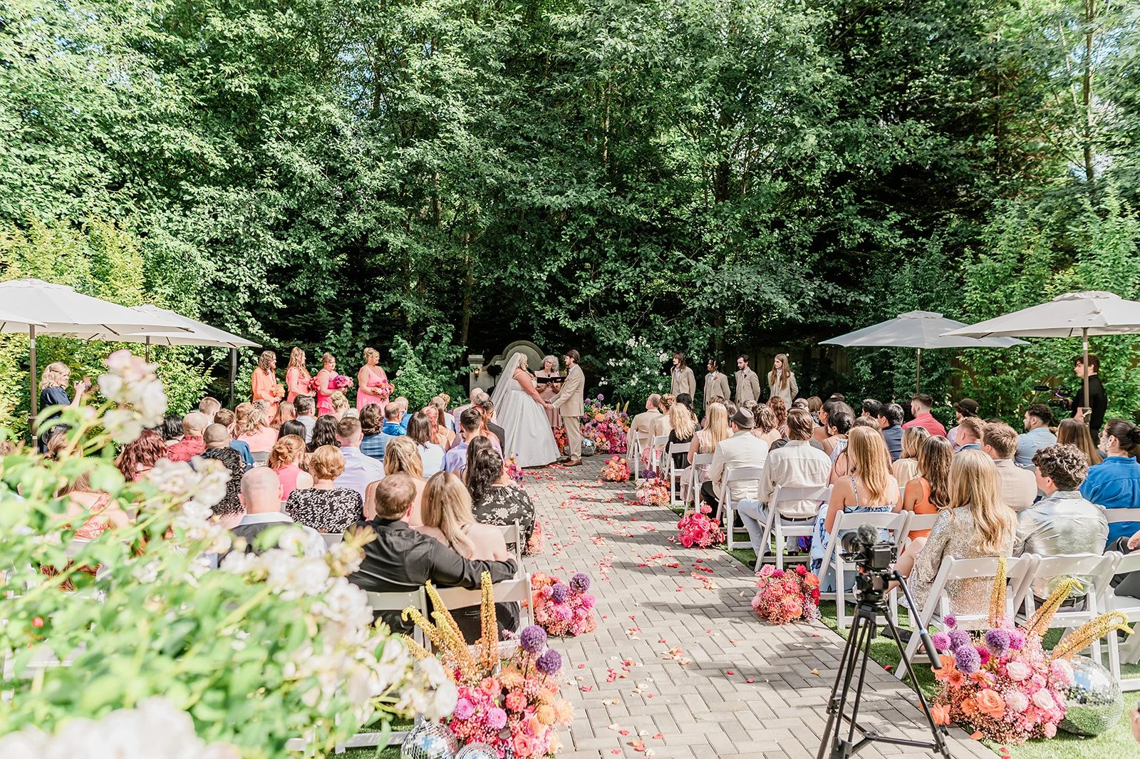 Guests seated for an outdoor wedding ceremony at Jackson Manor surrounded by lush garden landscaping