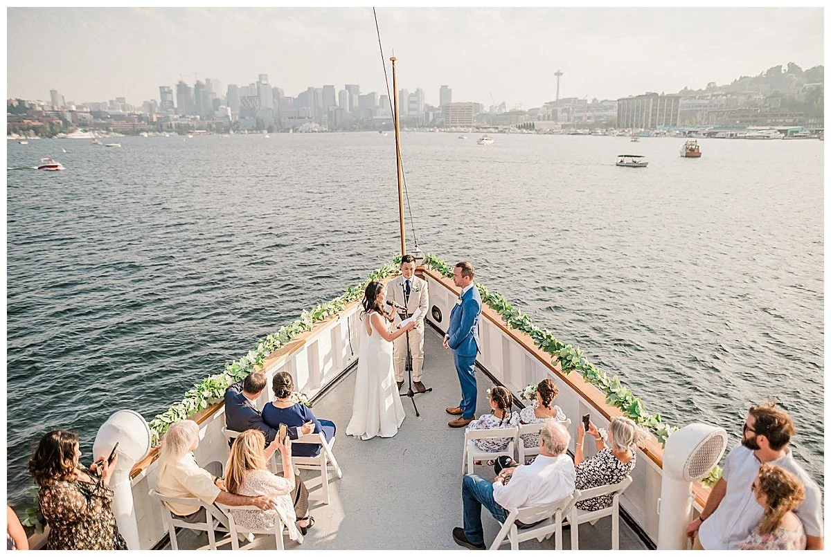 Wedding ceremony on the bow of a boat with the Seattle skyline behind, Virginia V