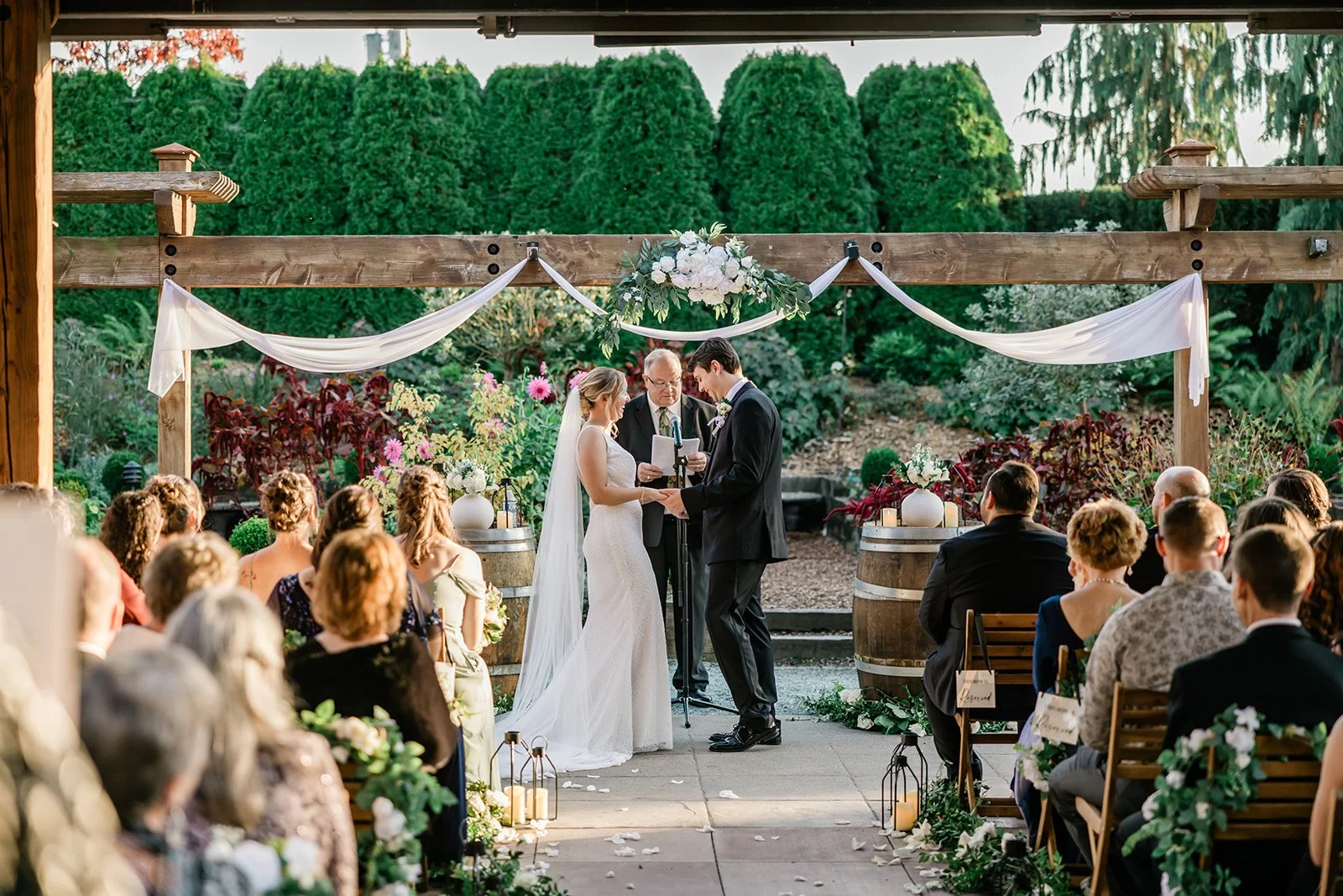 Wide shot of the Willows Lodge wedding ceremony with guests seated among garden florals
