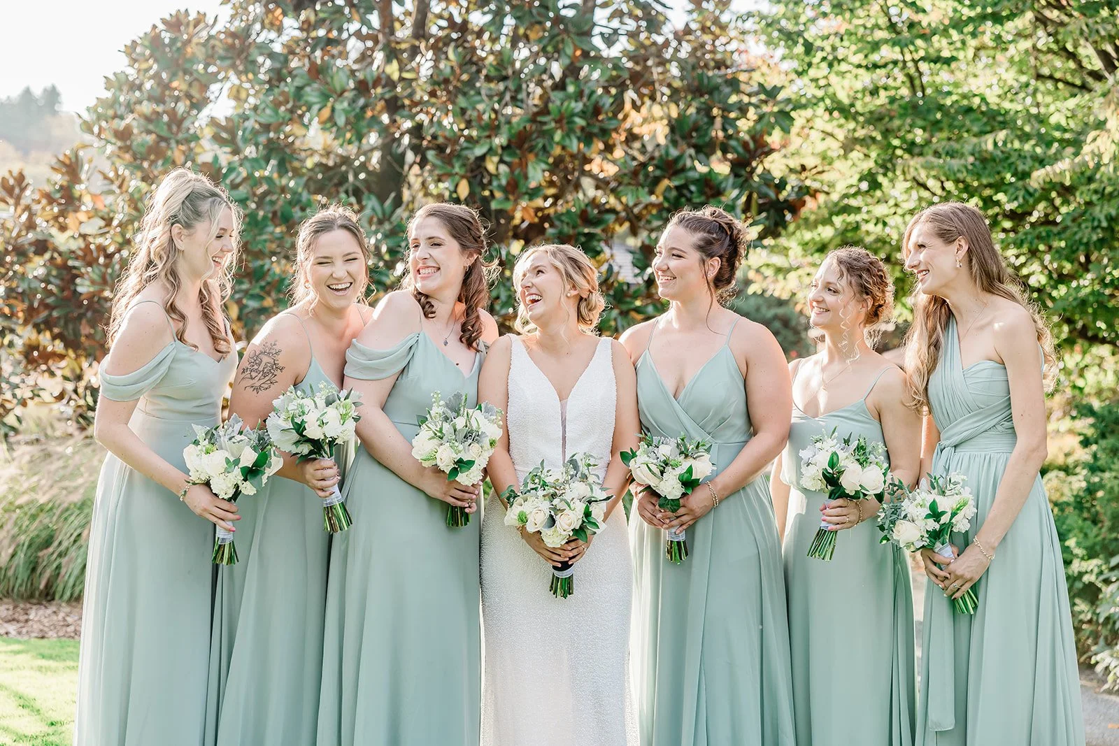 Bridesmaids in sage green under the magnolia tree at Willows Lodge, Woodinville WA
