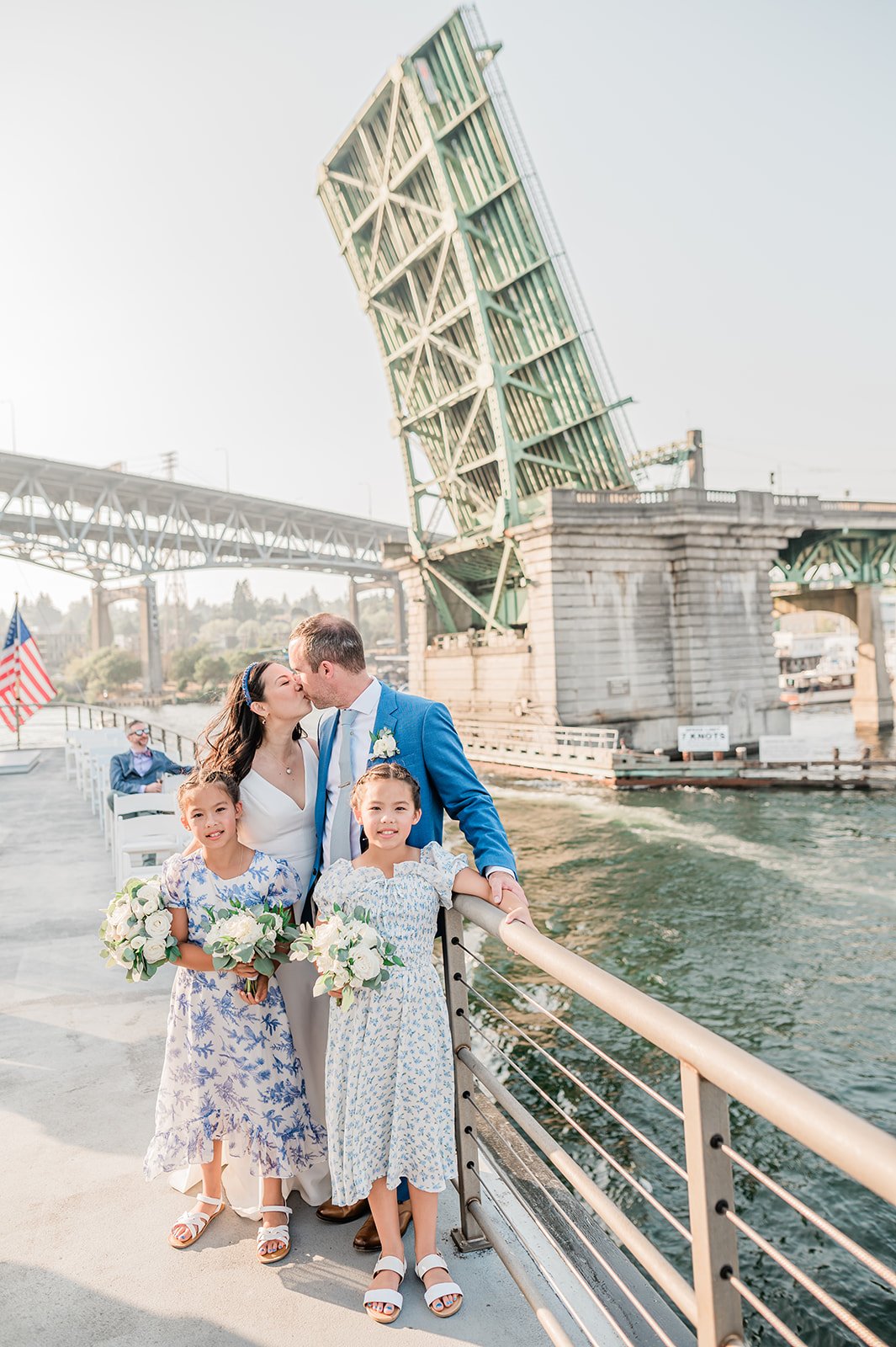 Family formal wedding portraits on a drawbridge with two flower girls