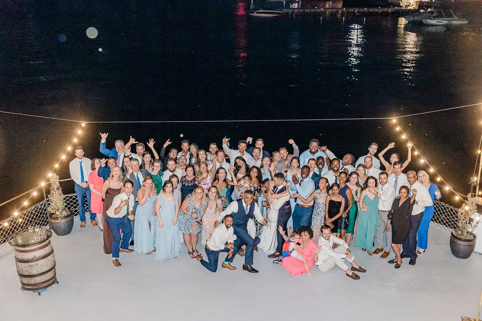 Wedding guests celebrating under string lights on a boat deck at night, MV Skansonia