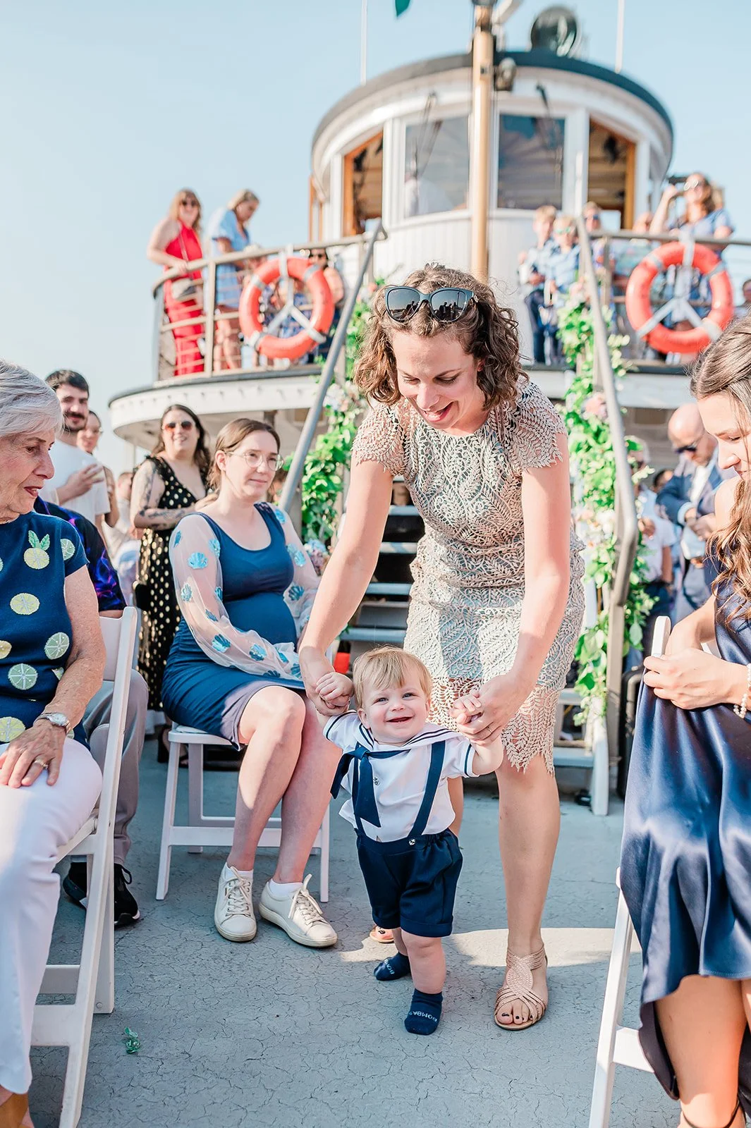 Toddler guest taking his first steps across the deck at a spring boat wedding