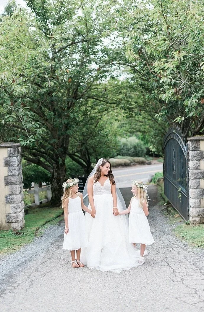 bride with flower girls in driveway at chateau lill
