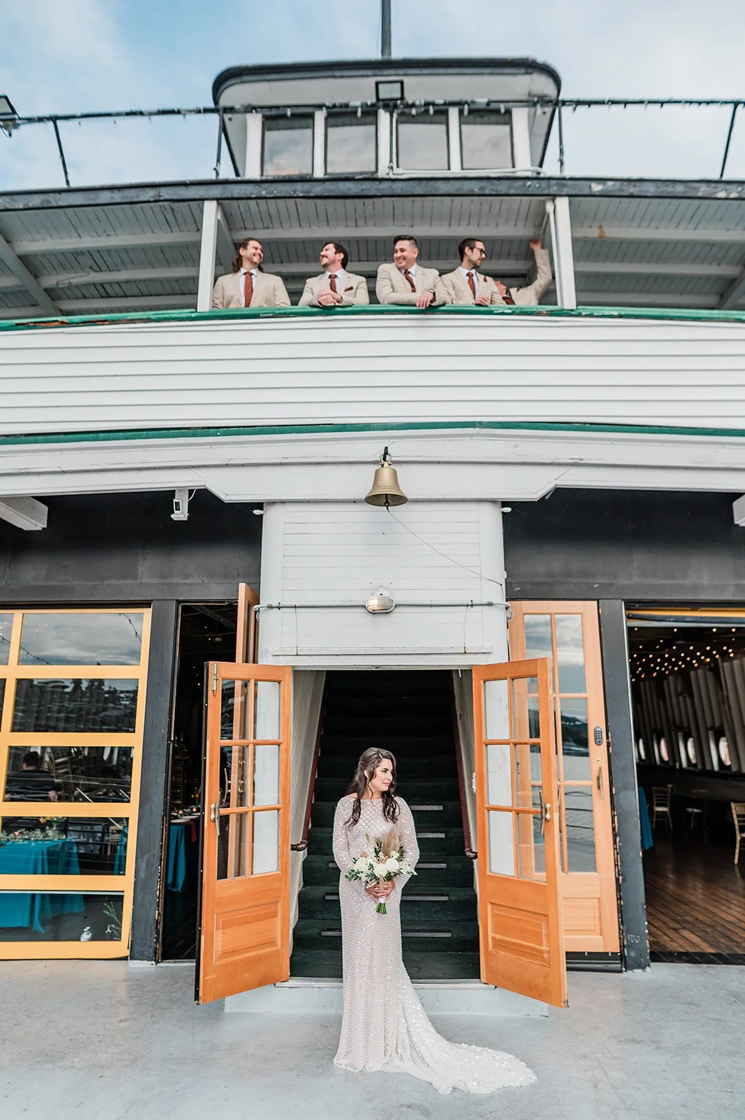 Bride in the MV Skansonia doorway with groomsmen on the upper deck