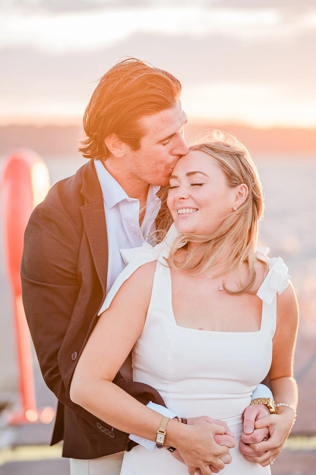 Fiancé kissing fiancée's cheek at golden hour during a Mukilteo engagement session