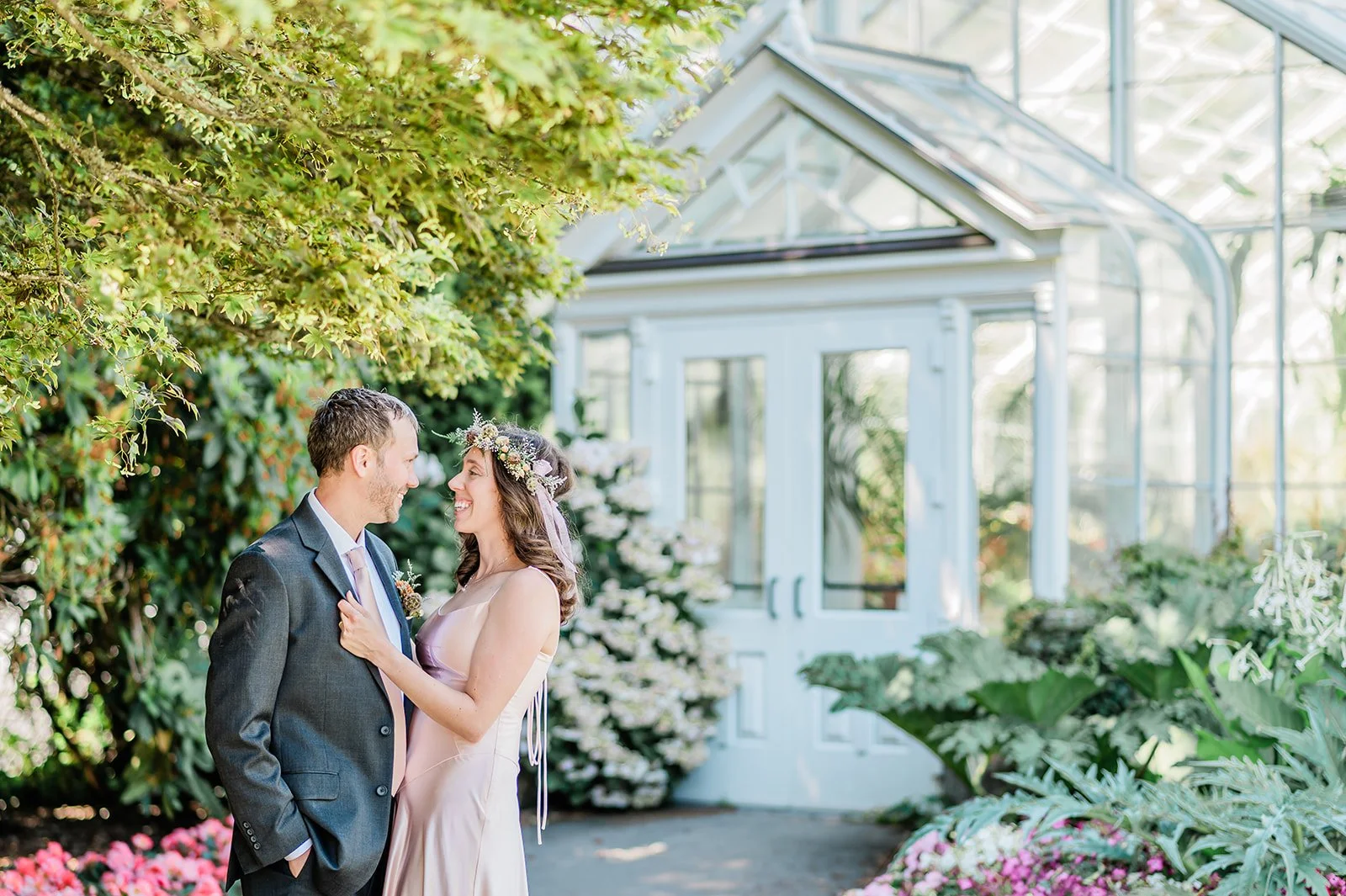 Bride and groom embracing outside the Volunteer Park Conservatory Seattle greenhouse