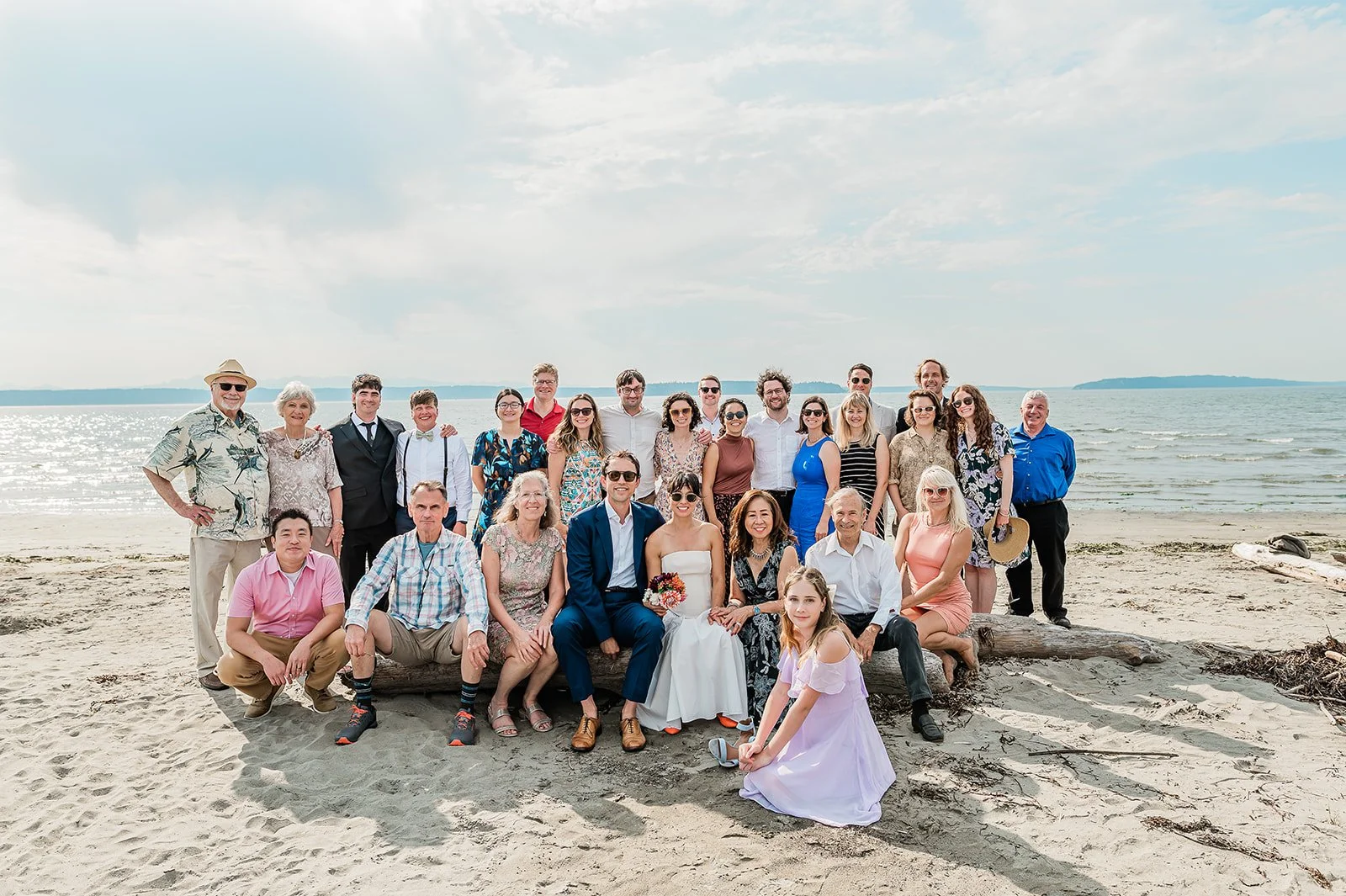 Small intimate wedding group photo on Jetty Island beach with the Salish Sea and San Juan Islands in the background