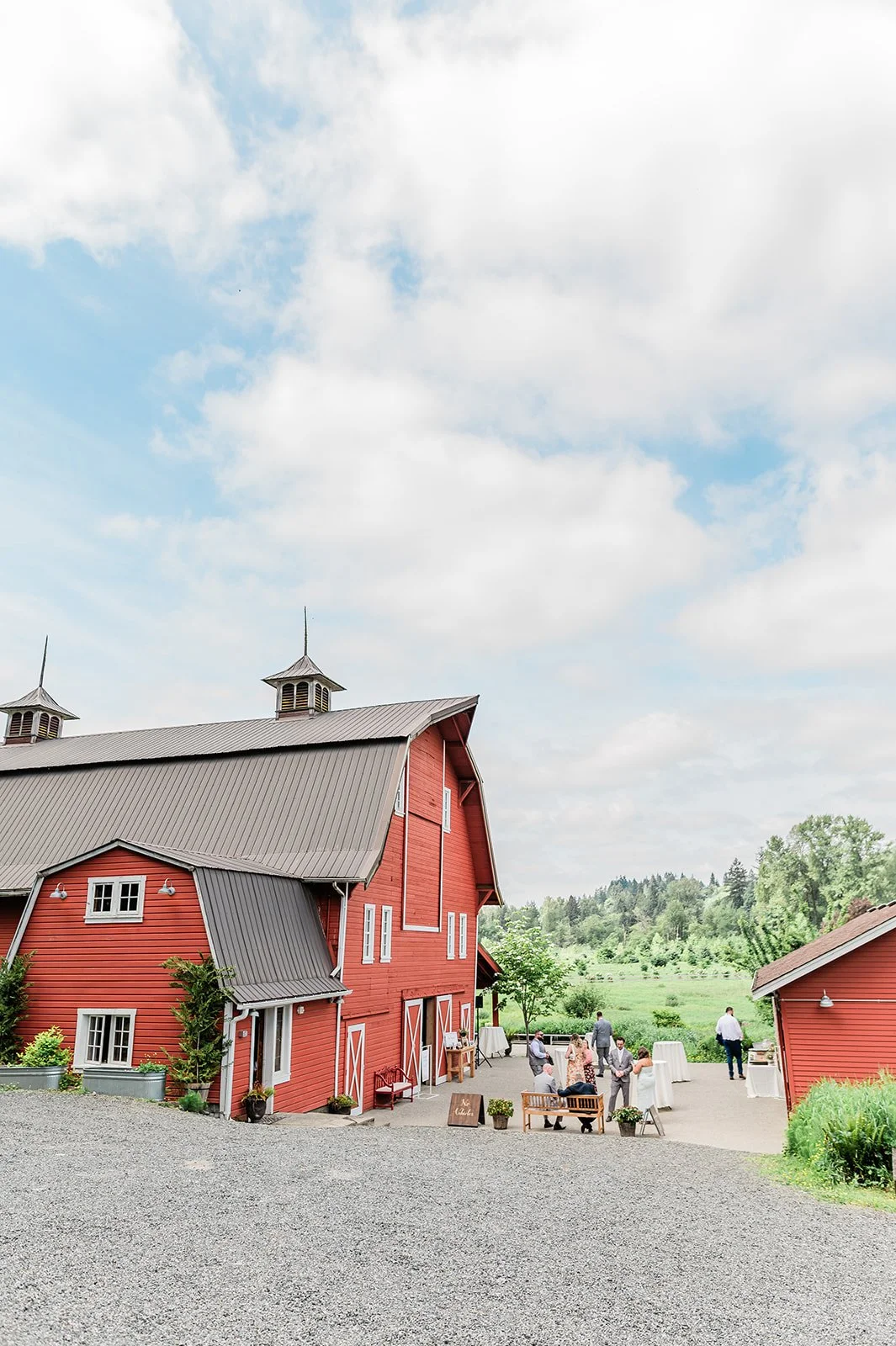 Historic red dairy barn with white trim under a blue sky at Marionfield Farm wedding venue