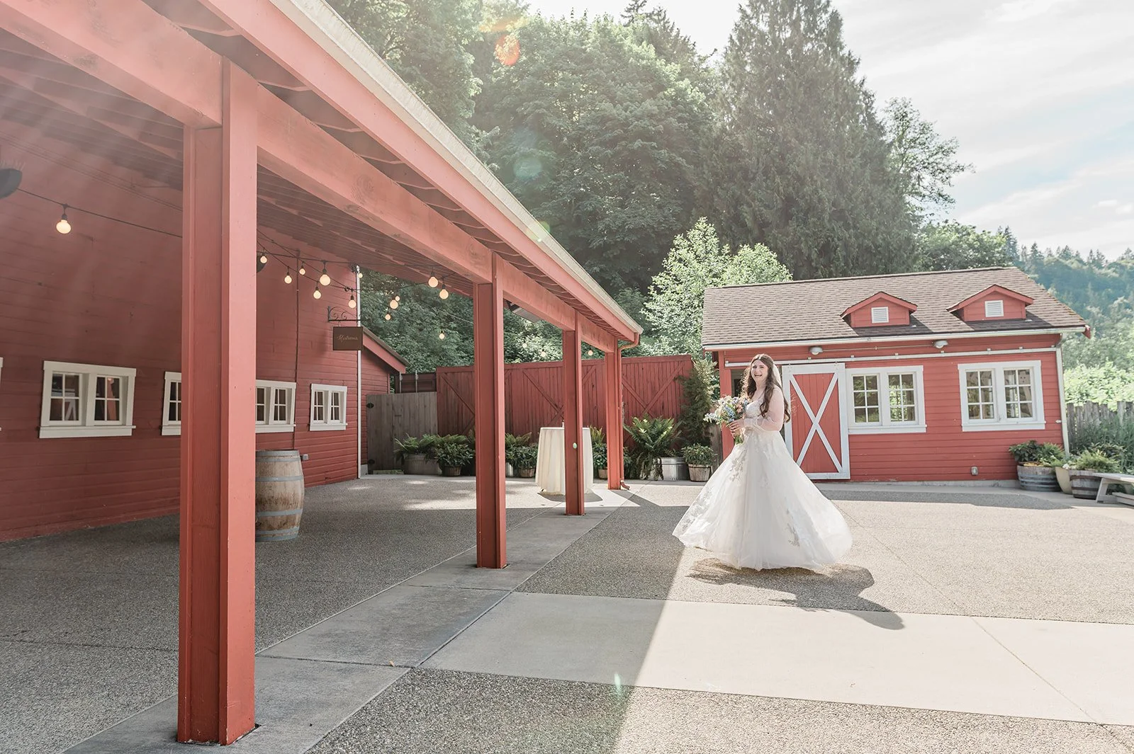 Bride walking beneath the long red covered breezeway at Marionfield Farm wedding venue