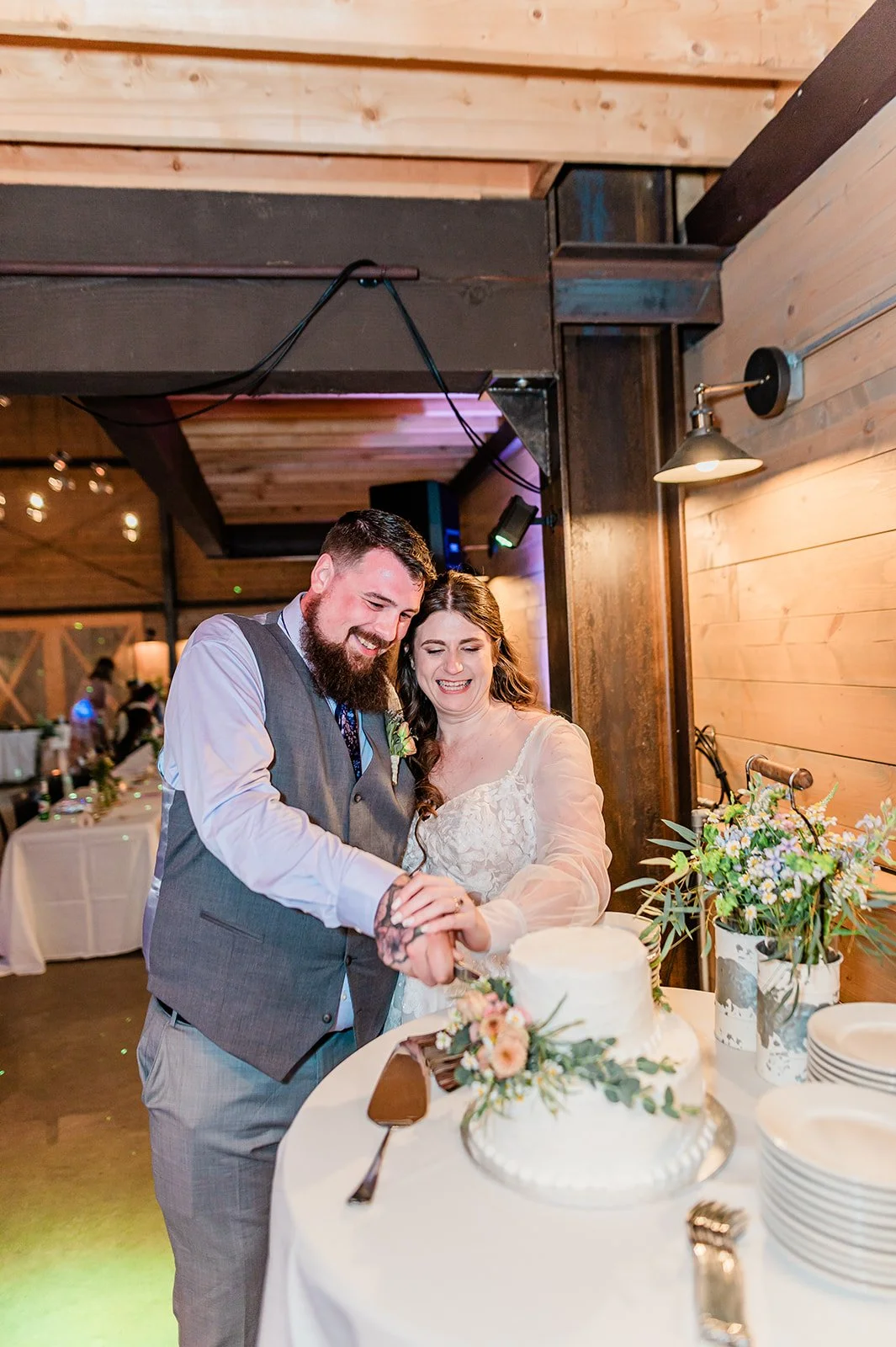 Bride and groom cutting their wedding cake in the barn at Marionfield Farm