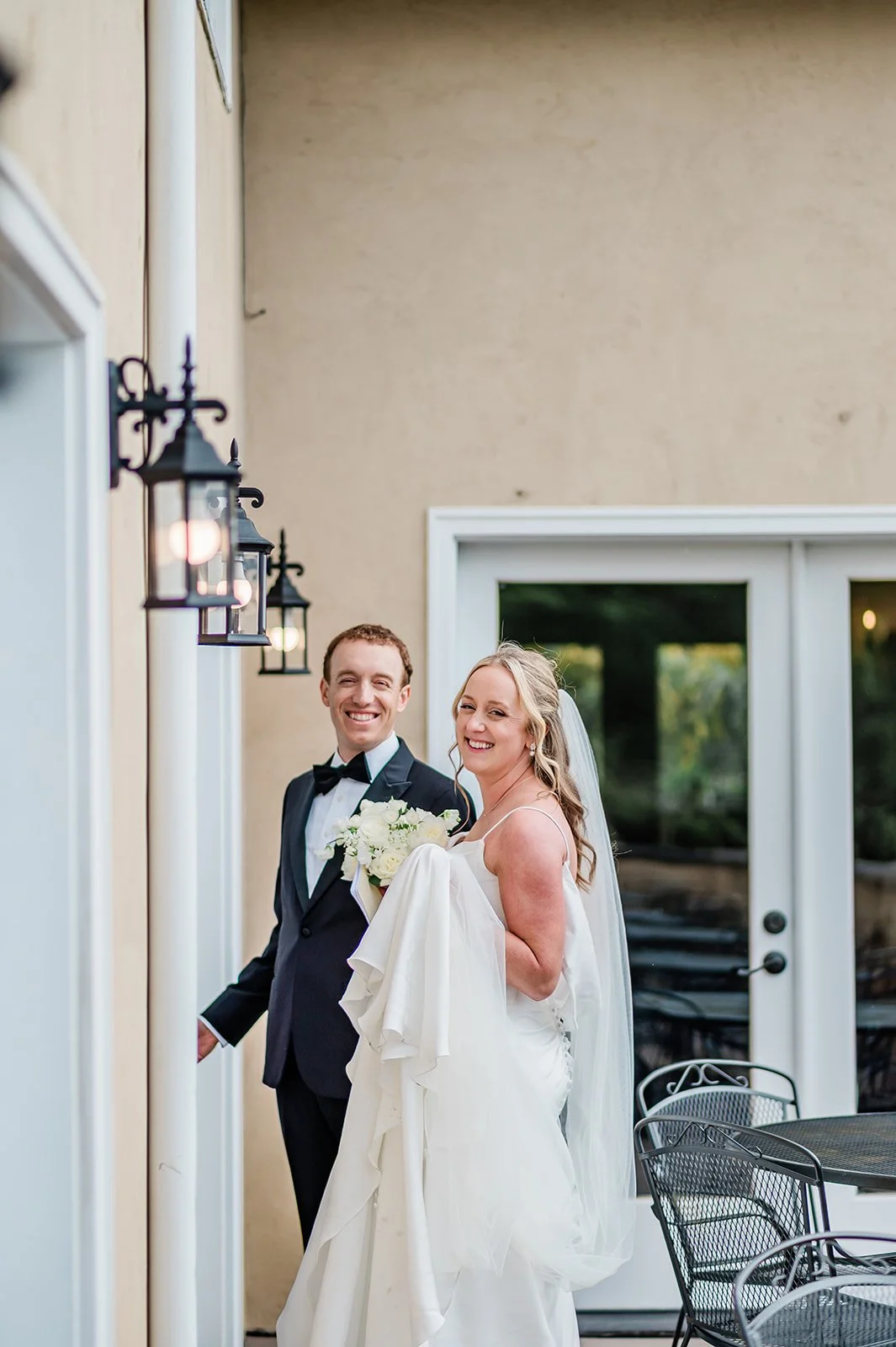 Couple smiling at the balcony doors with lanterns at Chateau Lill